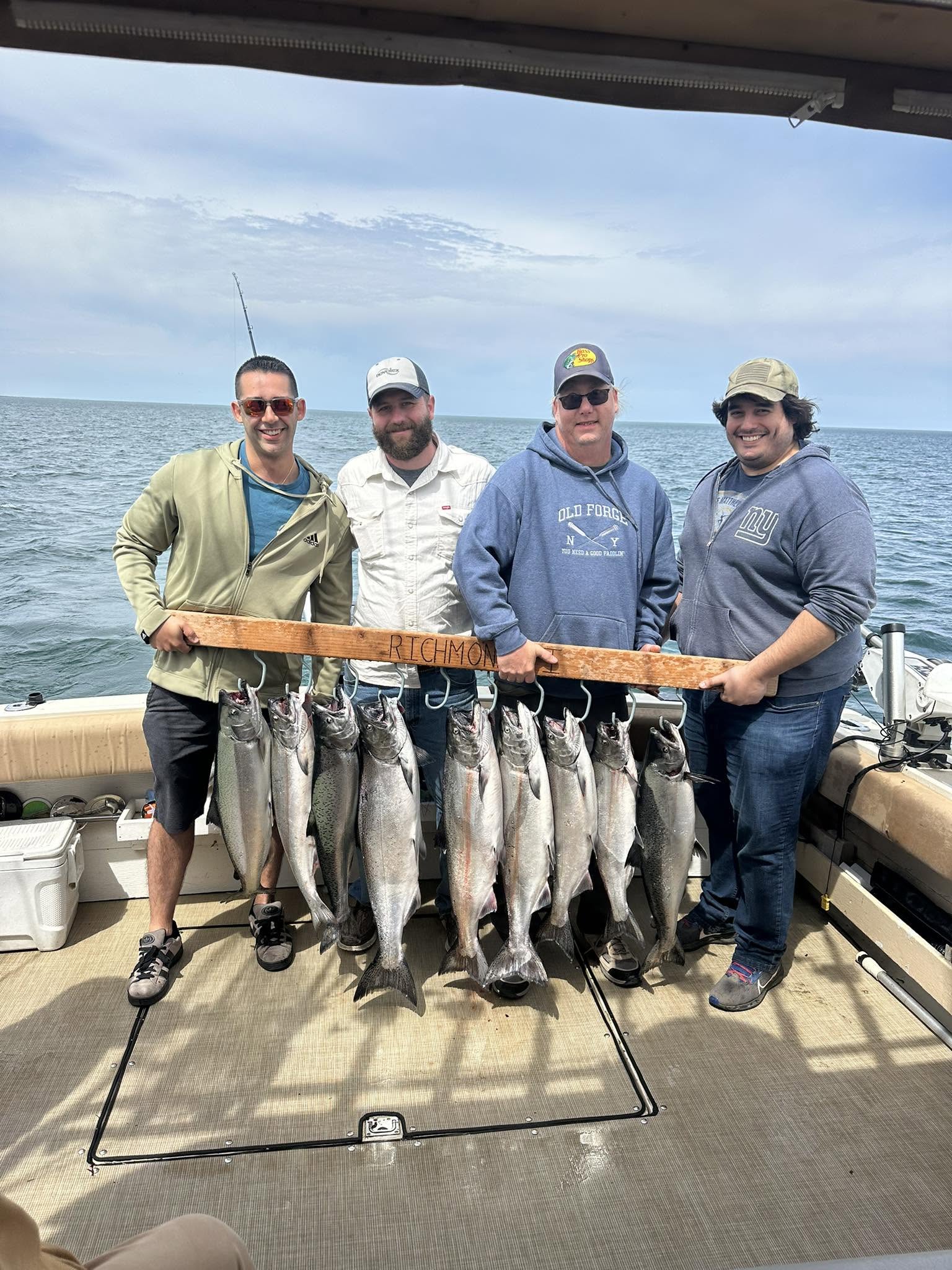 Successful fishing charter displaying multiple Chinook and Coho salmon catch on boat deck in South Bristol NY