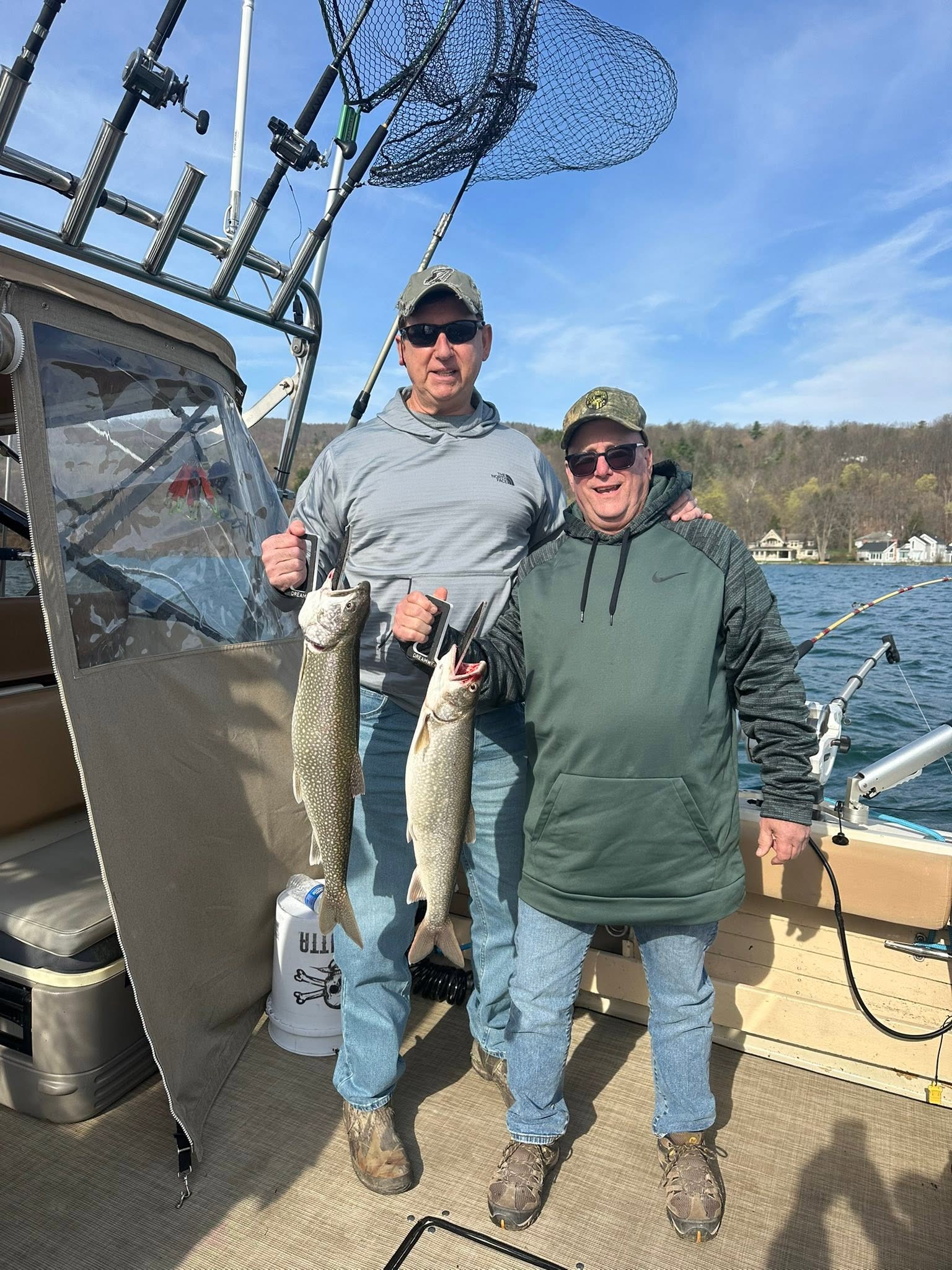 Two anglers displaying caught Lake Trout on fishing boat in South Bristol NY