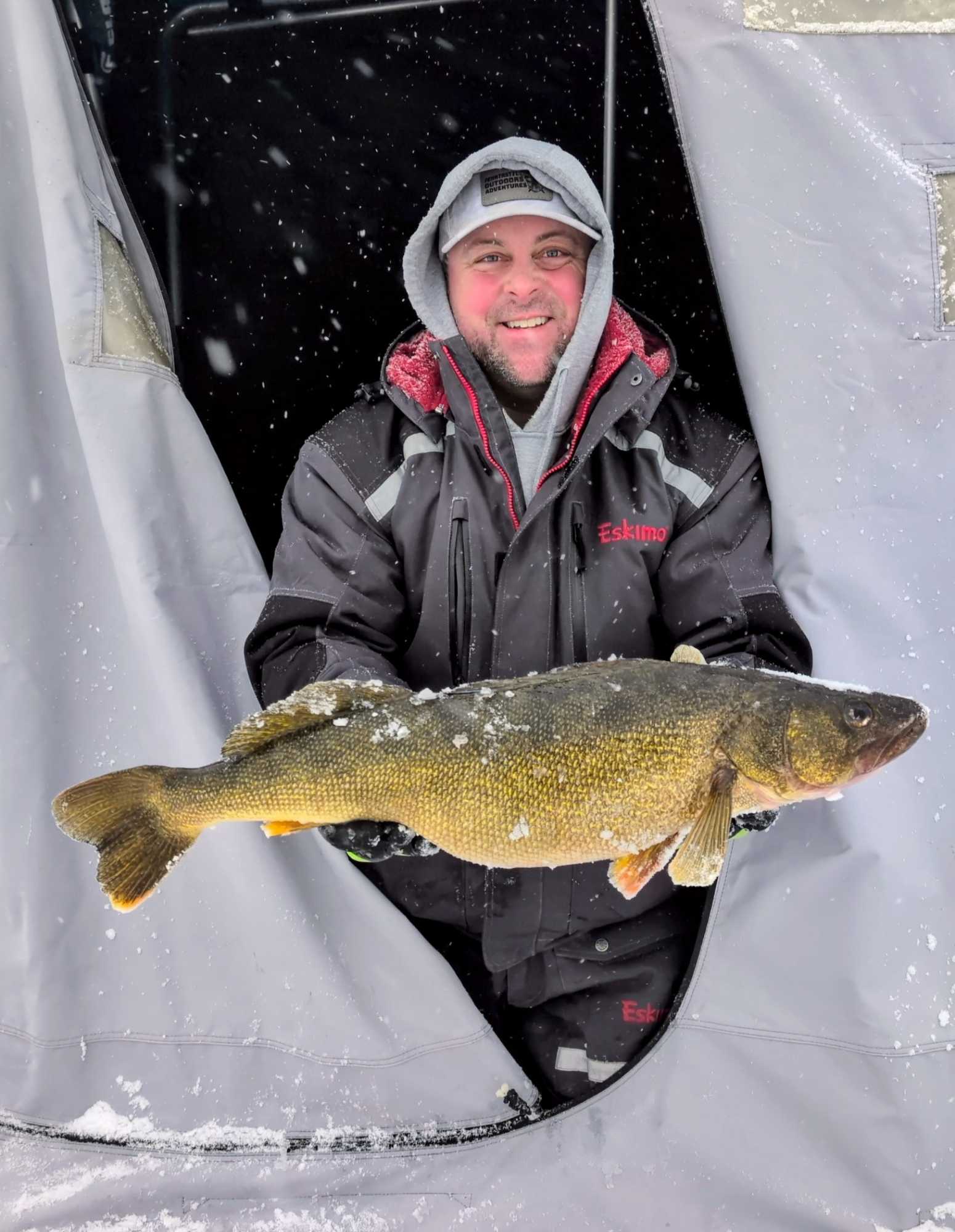 Ice fishing setup with tip-ups and electronics on frozen river for walleye and pike