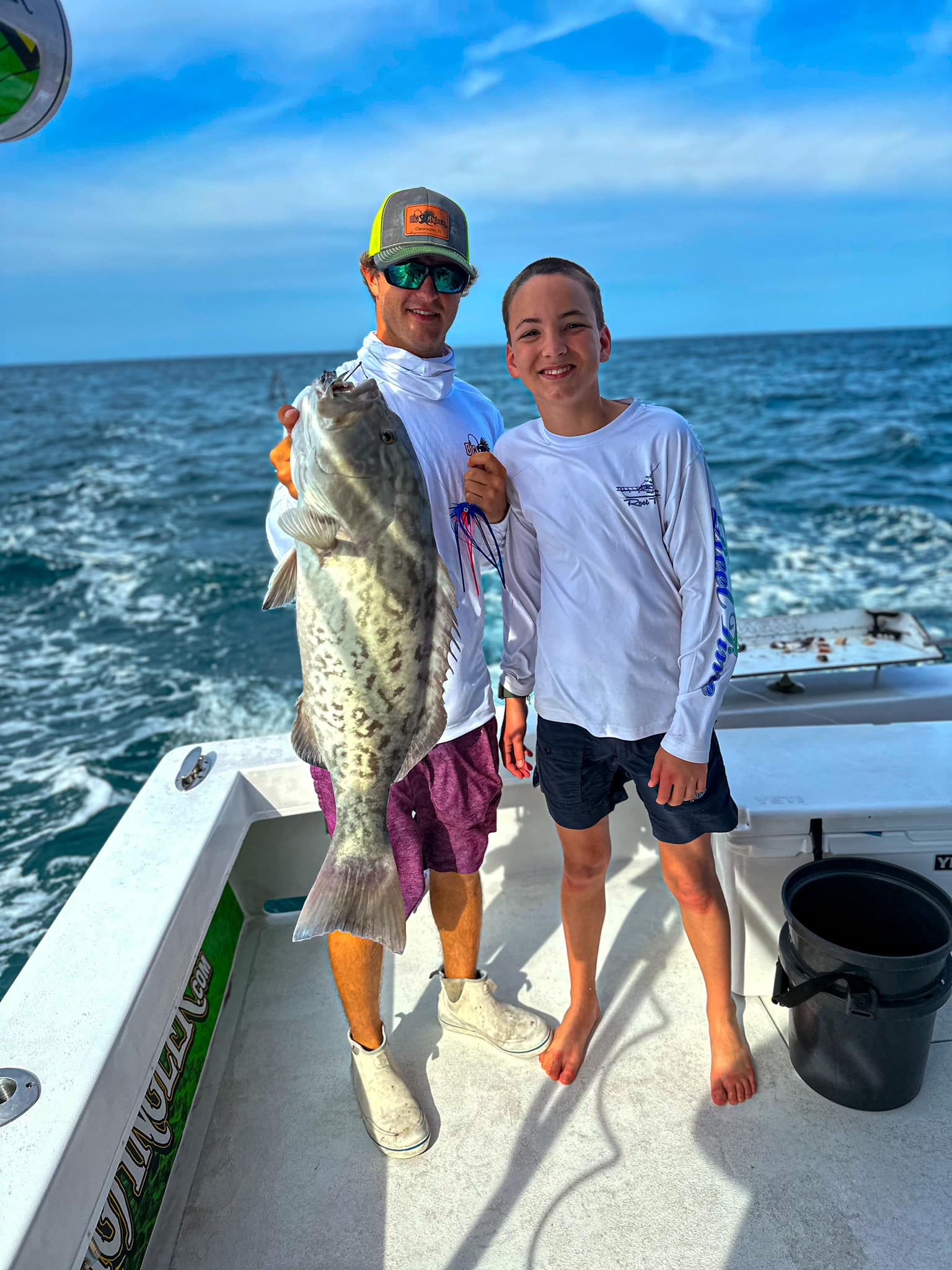 A fisherman holding a large Gag Grouper in Clearwater
