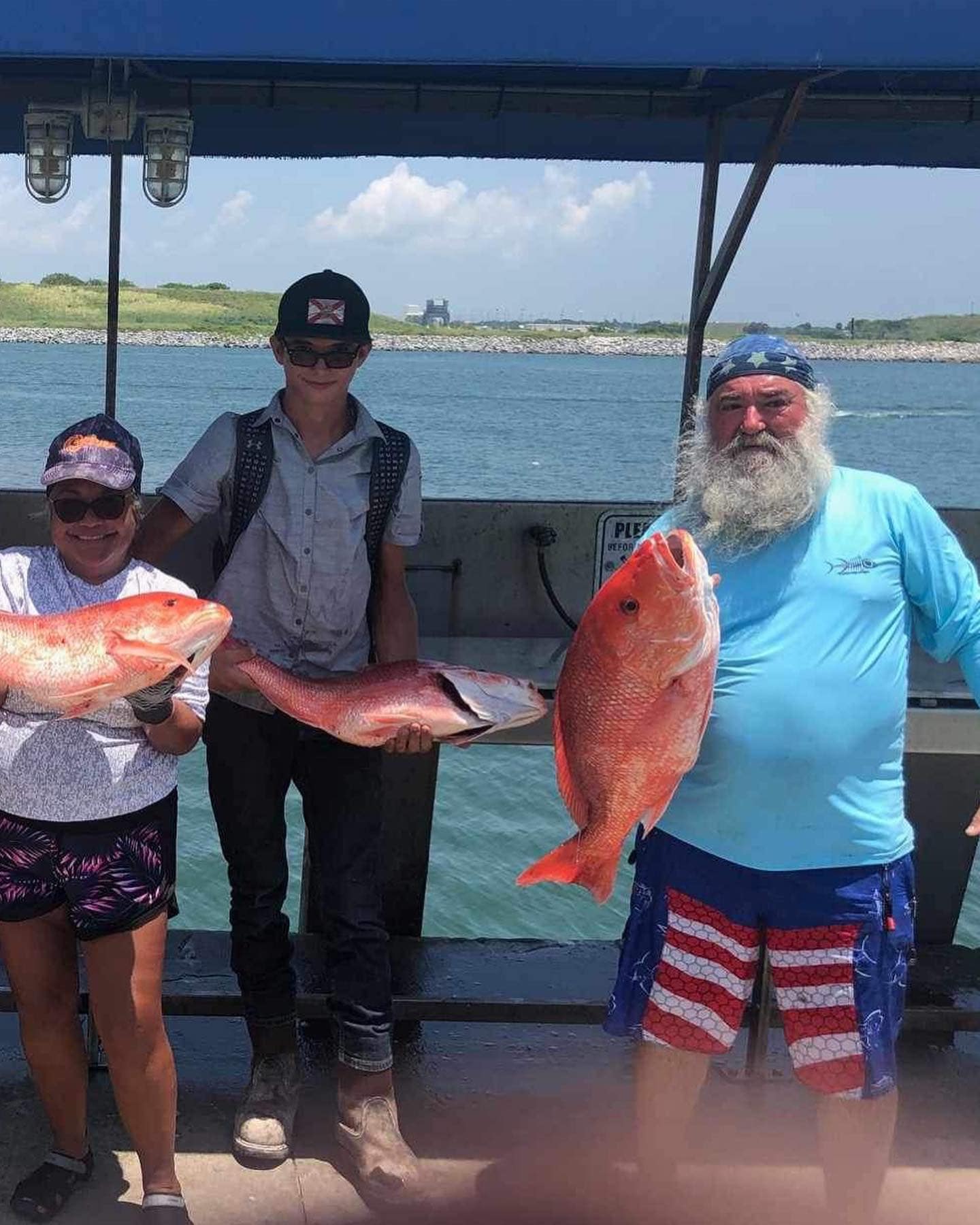 Three red snapper caught during fishing trip displayed on boat deck