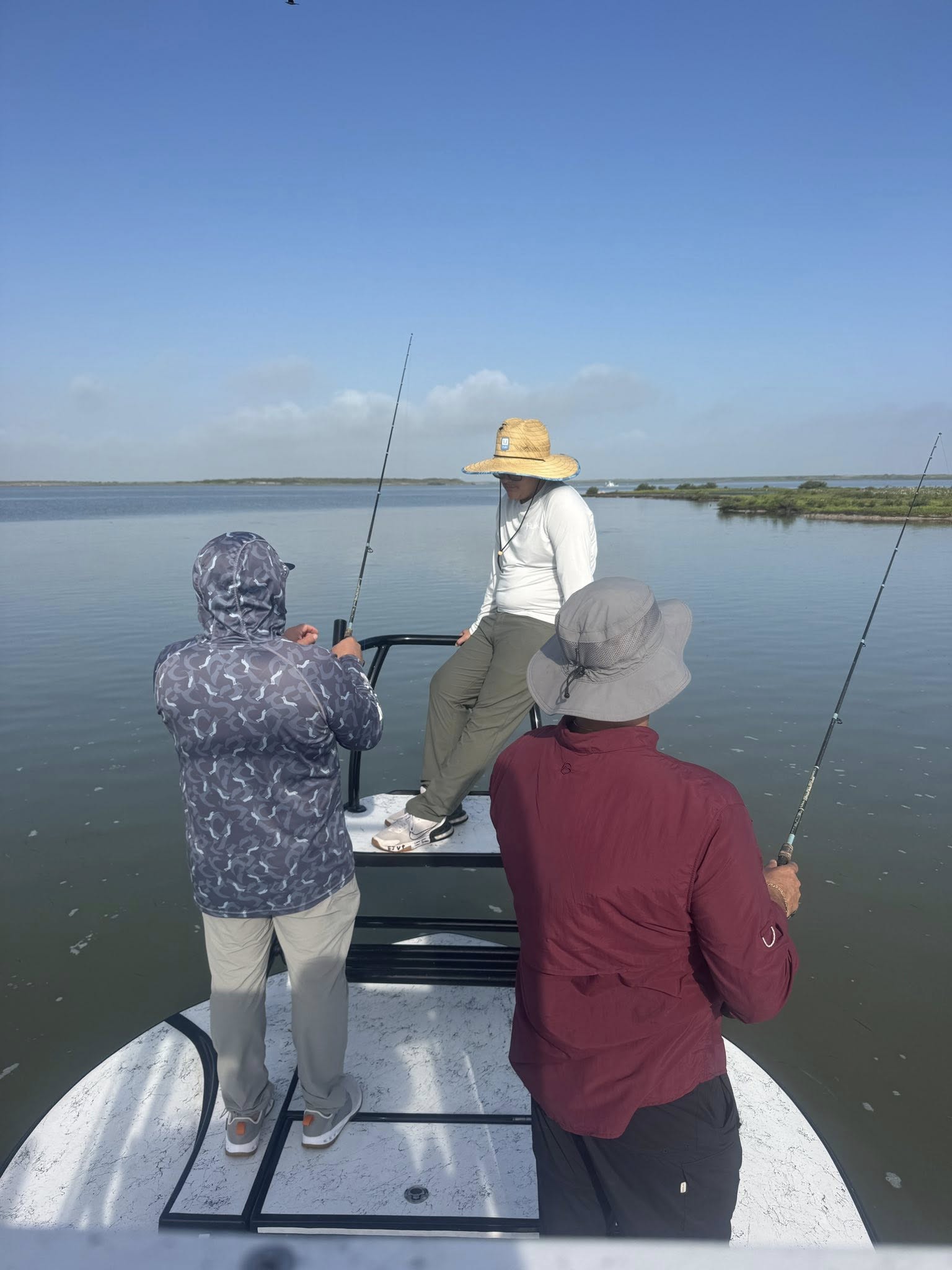 Fishing boat on calm waters in Arroyo City TX with multiple fishing rods deployed
