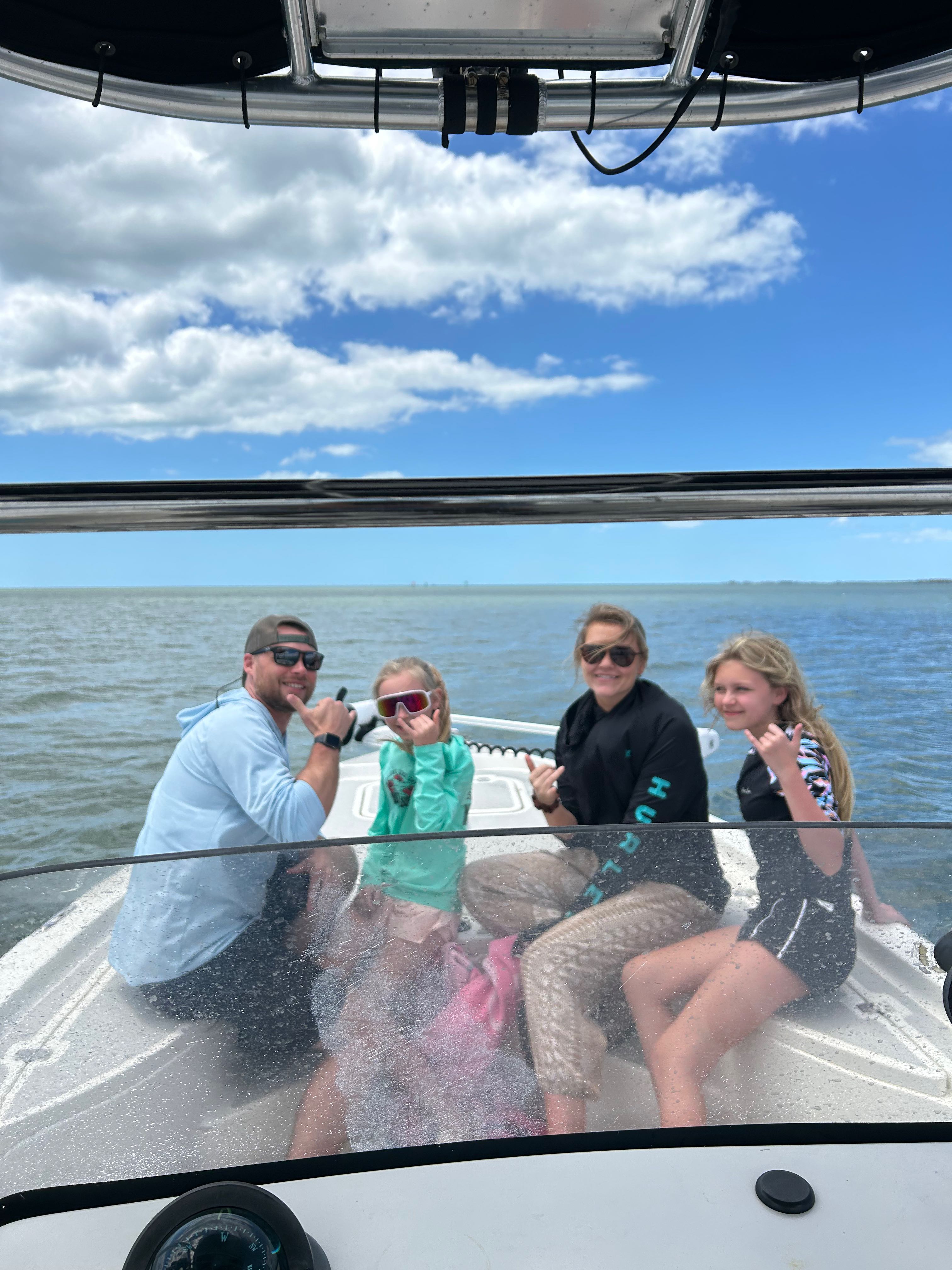 Family enjoying a boat cruise on calm waters in Crystal River FL with clear skies overhead