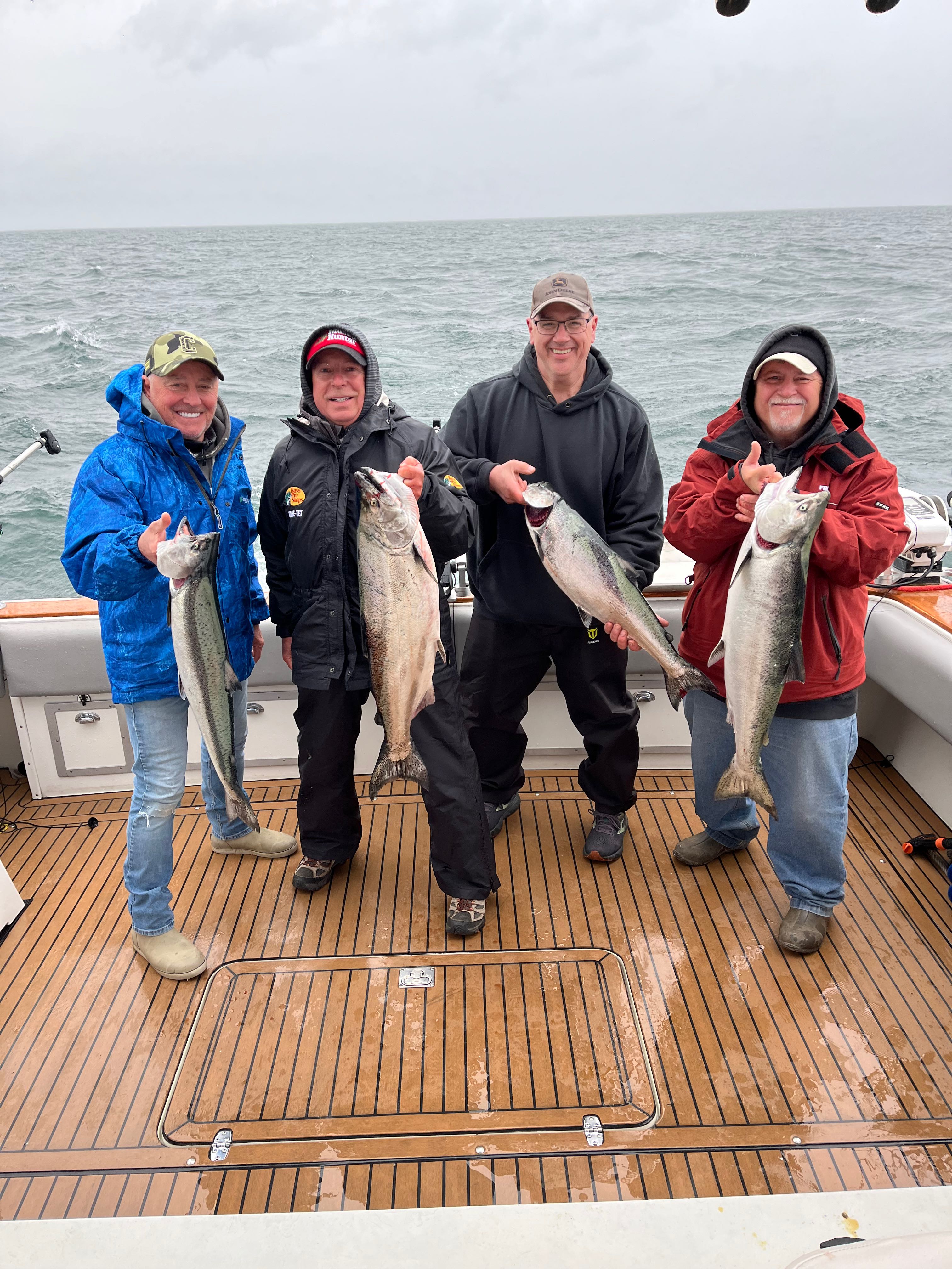 Four anglers displaying fresh caught Chinook salmon on fishing boat deck at Sodus Point NY