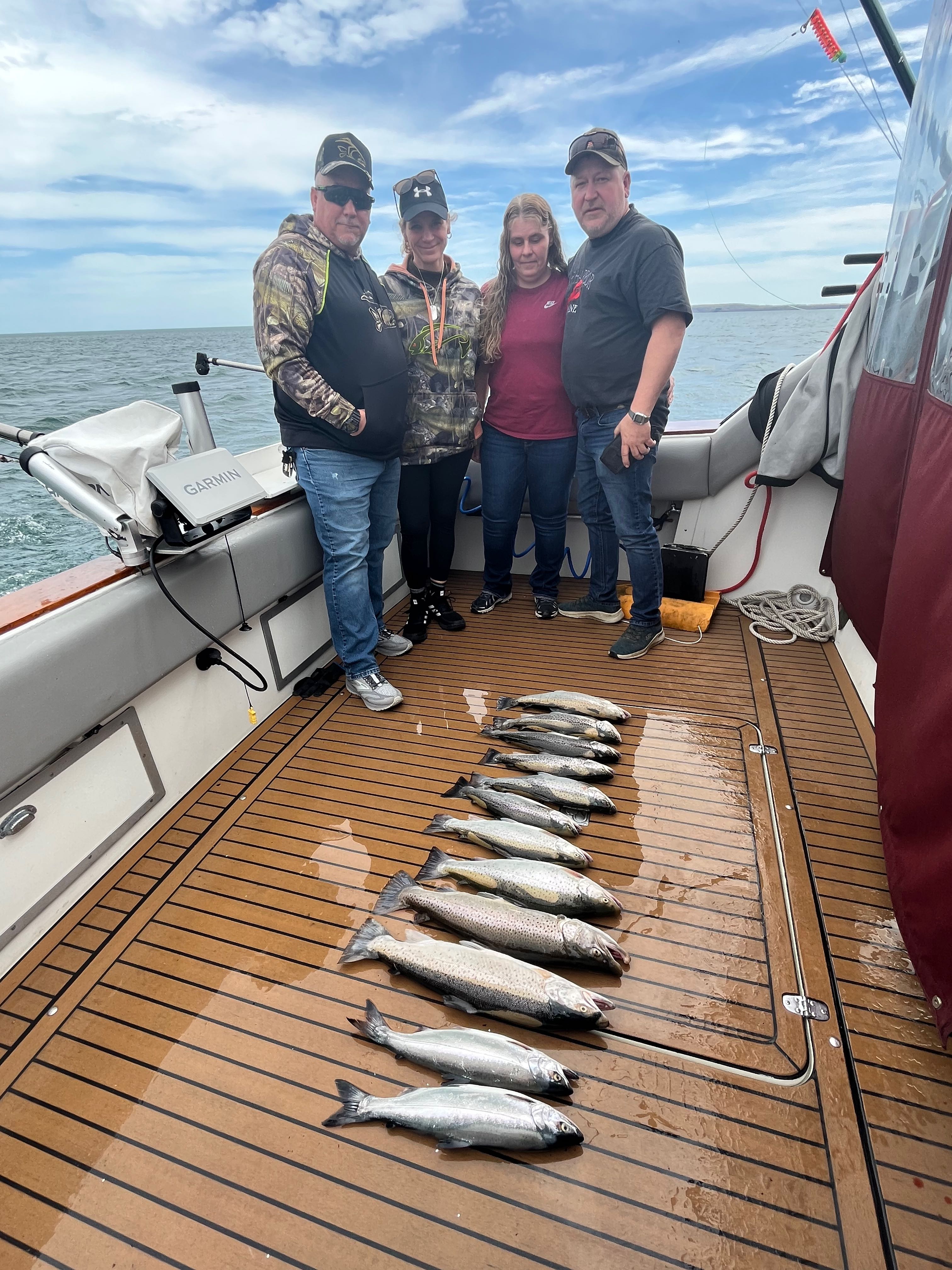 Successful salmon fishing charter at Sodus Point NY with catch of coho and sockeye salmon displayed on boat deck