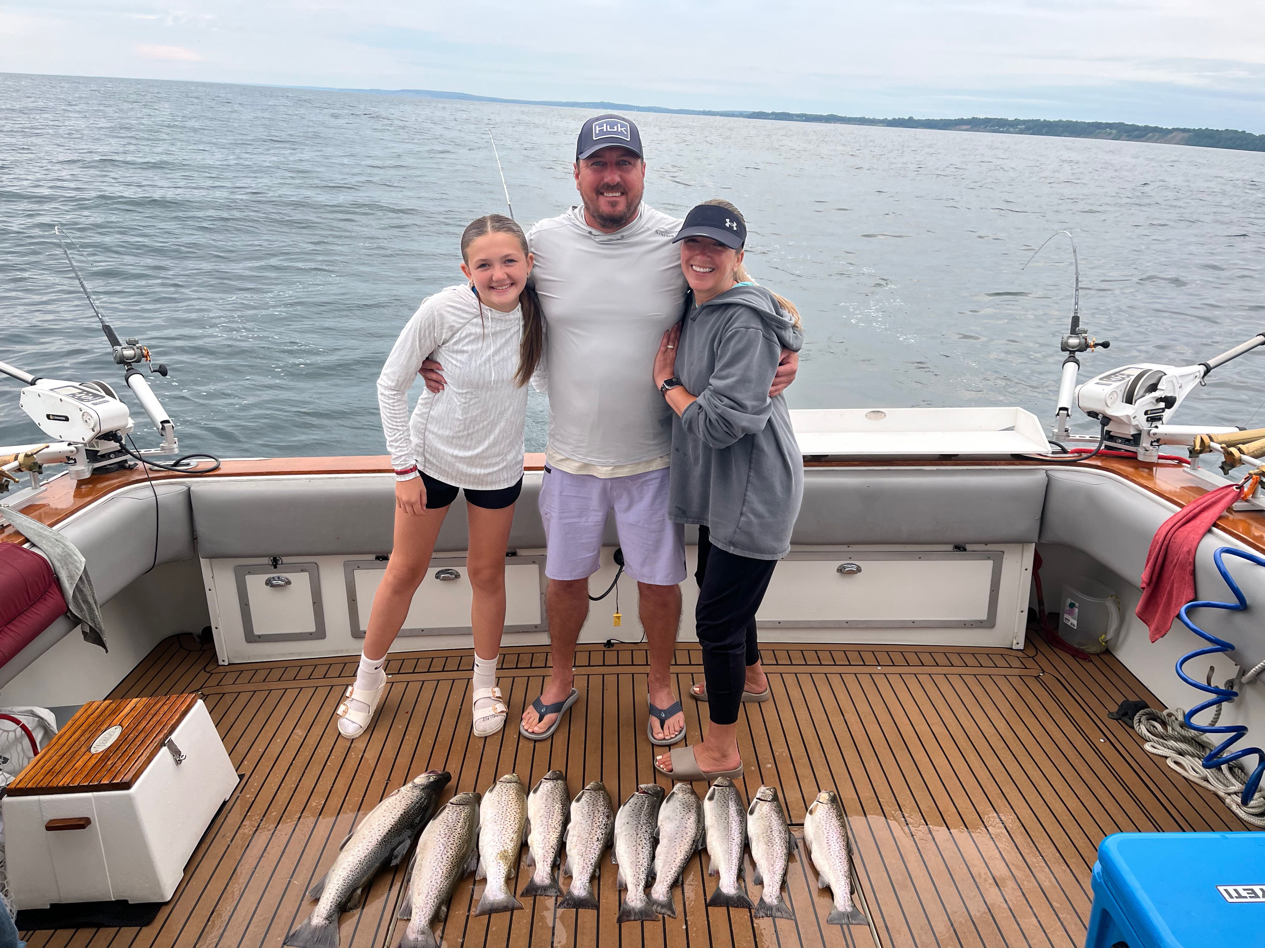 Successful fishing trip in Sodus Point NY with brown trout and rainbow trout catch displayed on boat deck
