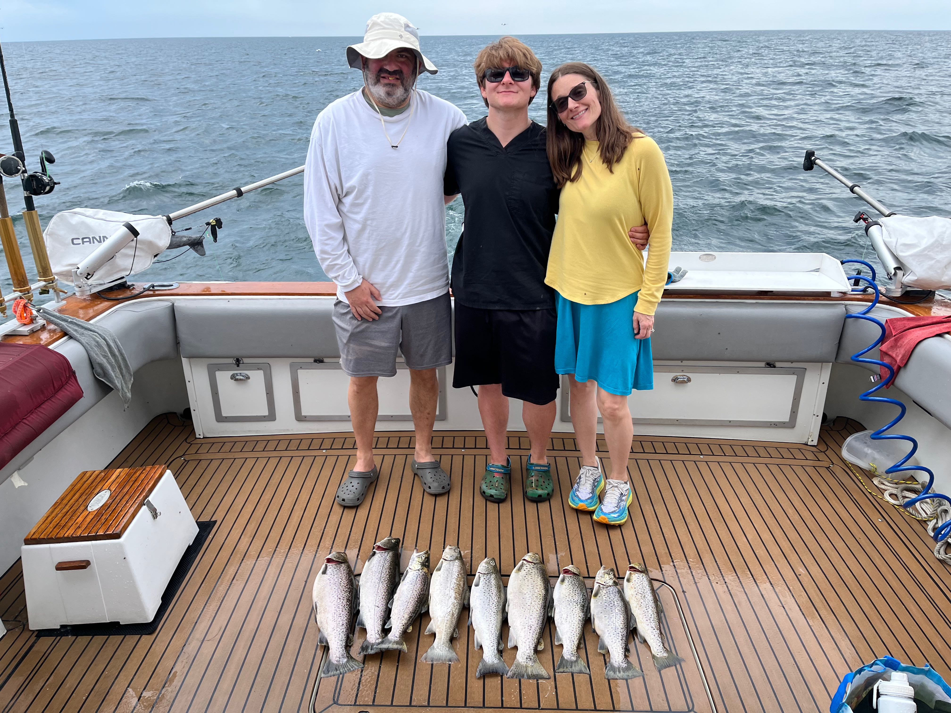 Fresh caught rainbow trout, Atlantic salmon, and brown trout displayed on fishing boat deck at Sodus Point NY