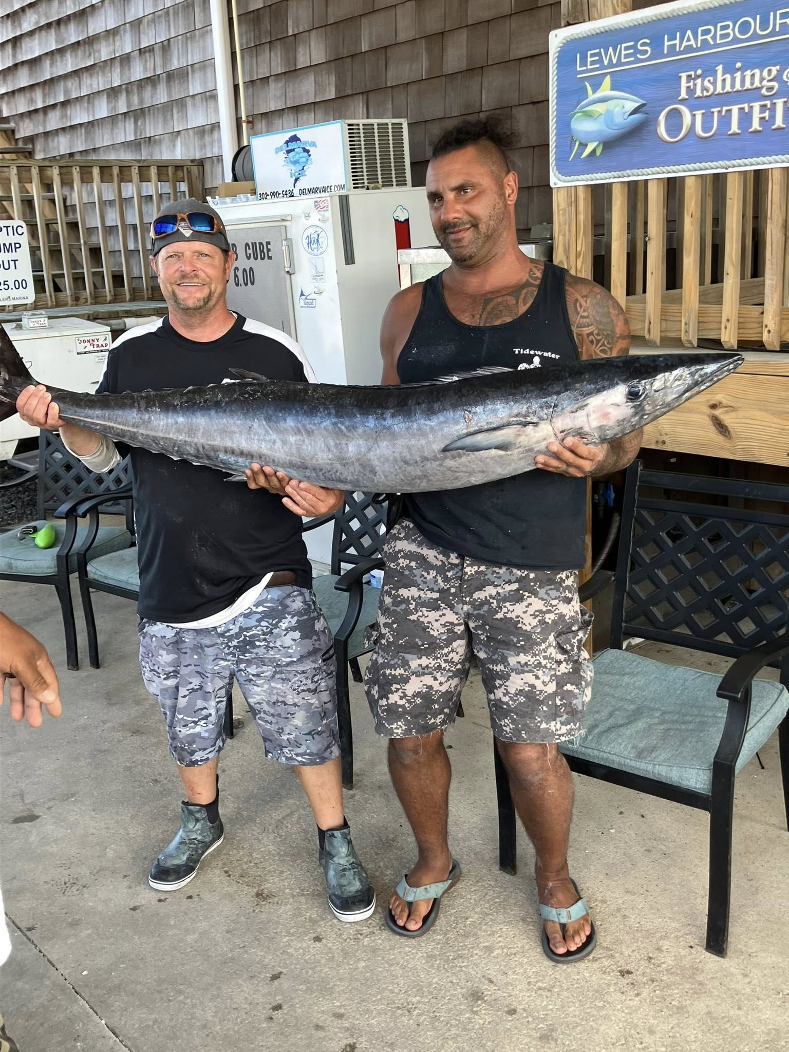 Two anglers holding large wahoo fish catch at Lewes Harbour fishing outfitter in Delaware