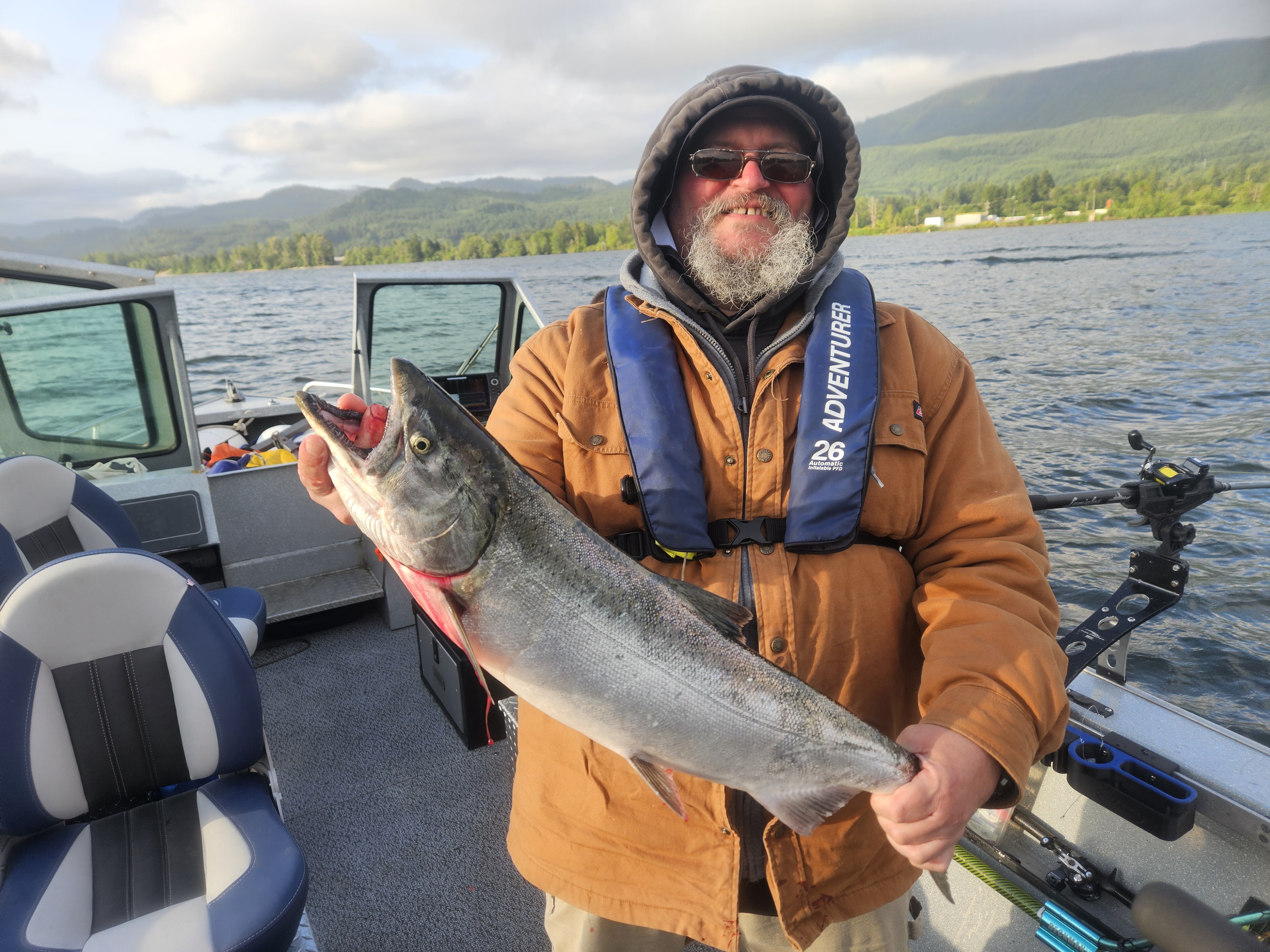 Columbia River spring chinook salmon fishing from private boat with angler holding catch