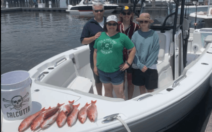 Four anglers posing on the SC dock with their catch