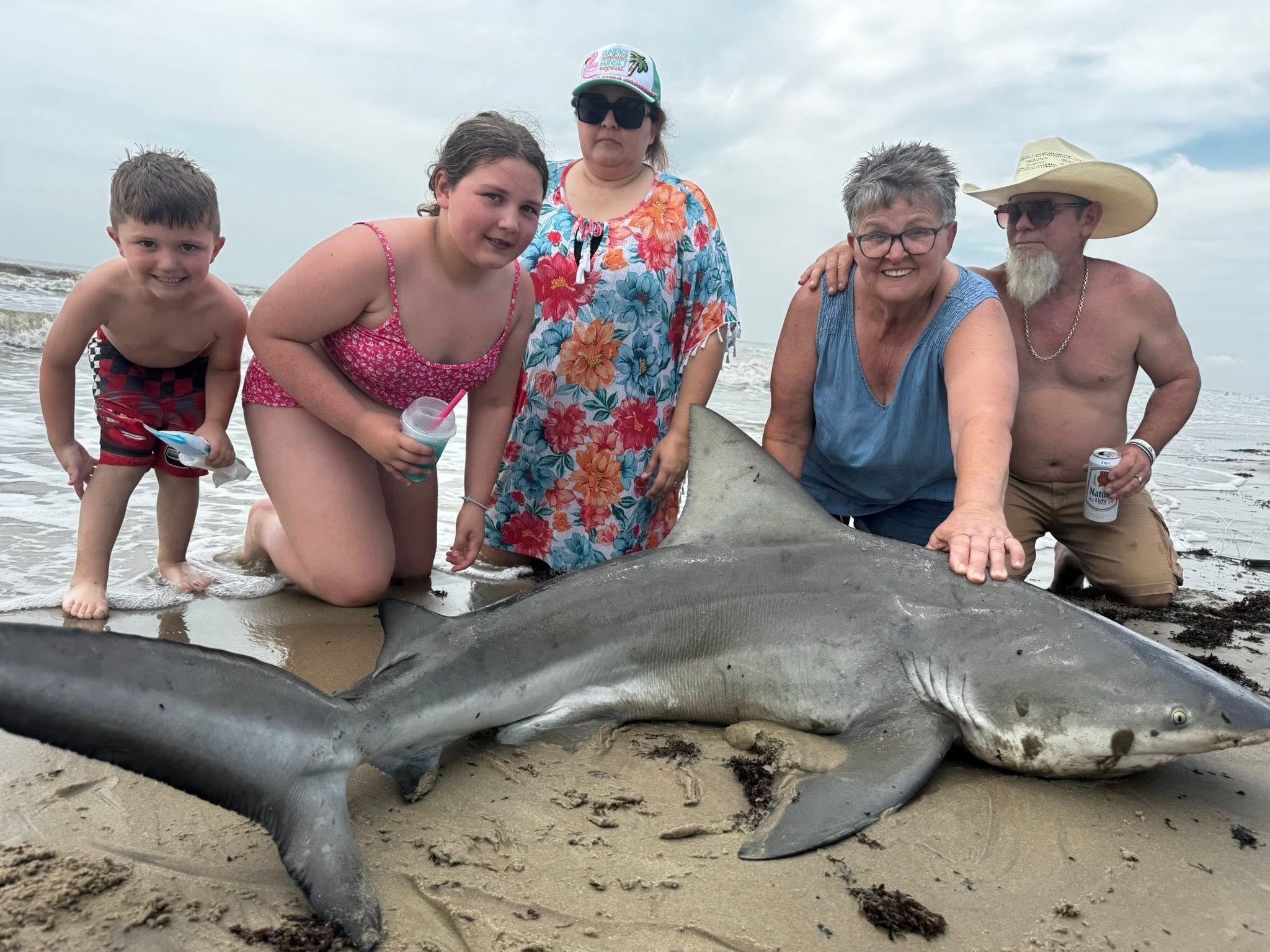 Large blacktip shark caught on Bolivar Peninsula TX beach with fishing group posing for photo