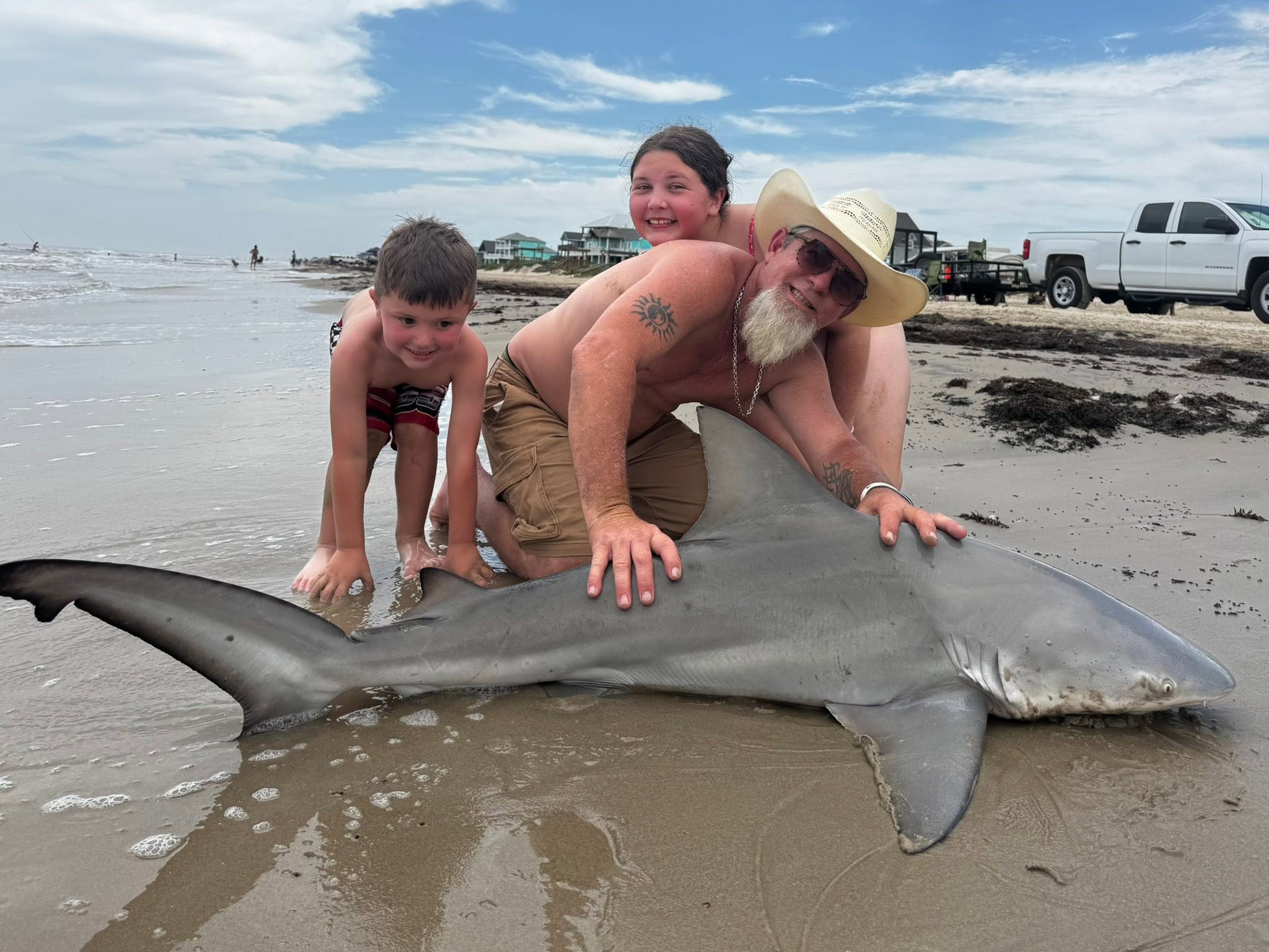 Bull shark caught fishing on Bolivar Peninsula TX beach with multiple people posing