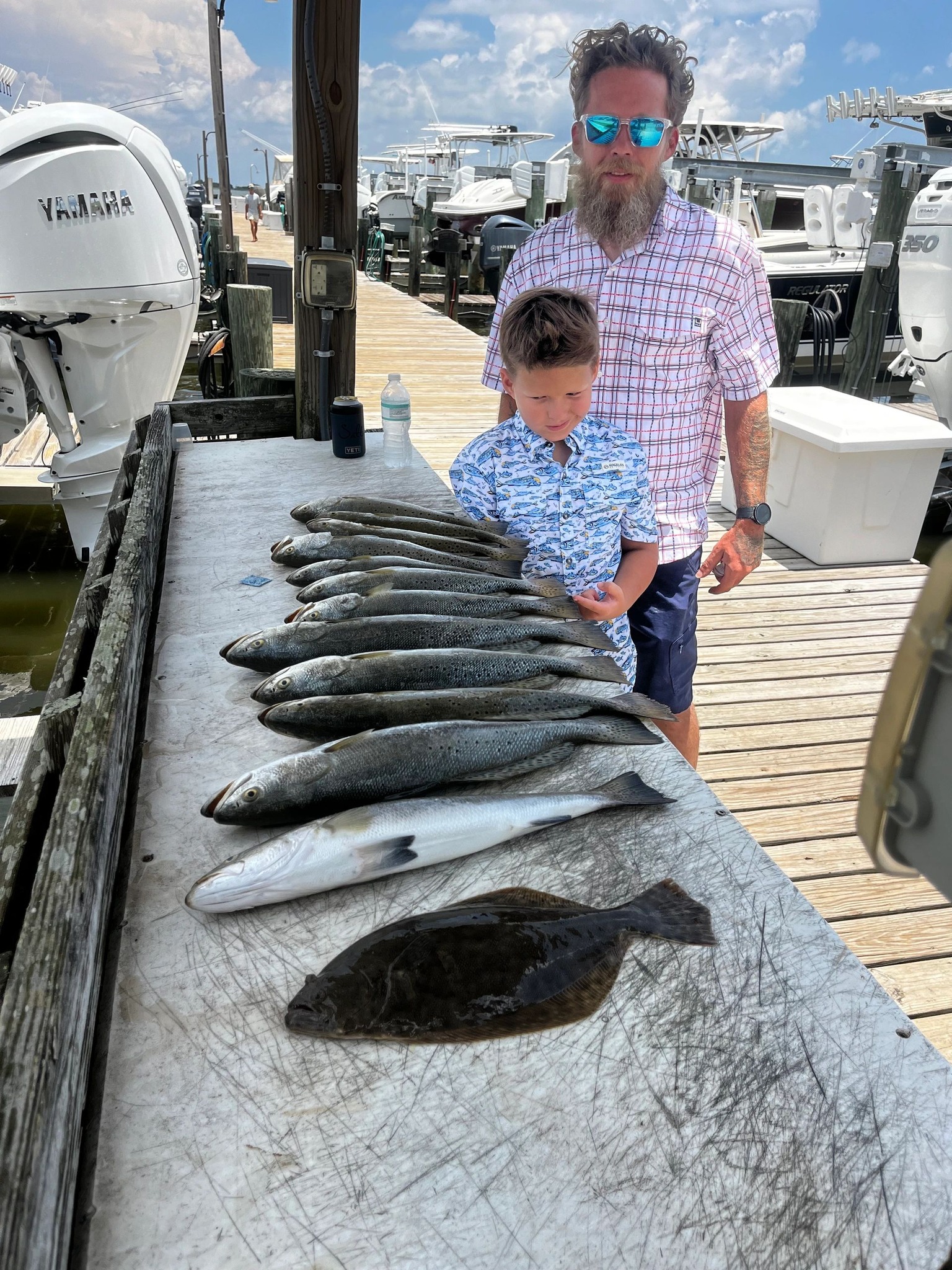 Fishing catch display on boat deck at Dauphin Island AL showing multiple fish including Southern Flounder