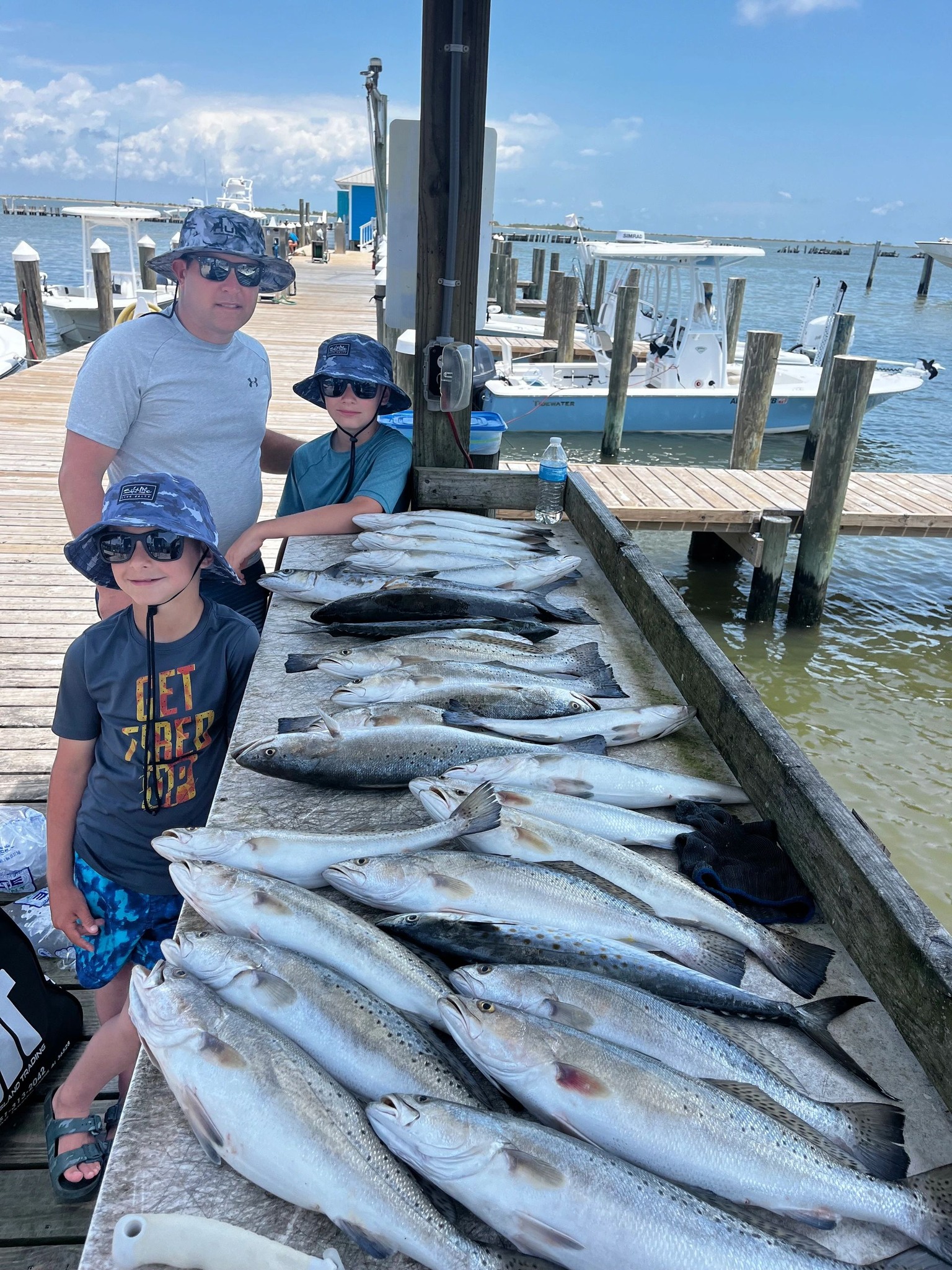 Large catch of speckled trout displayed on dock after fishing charter in Dauphin Island AL