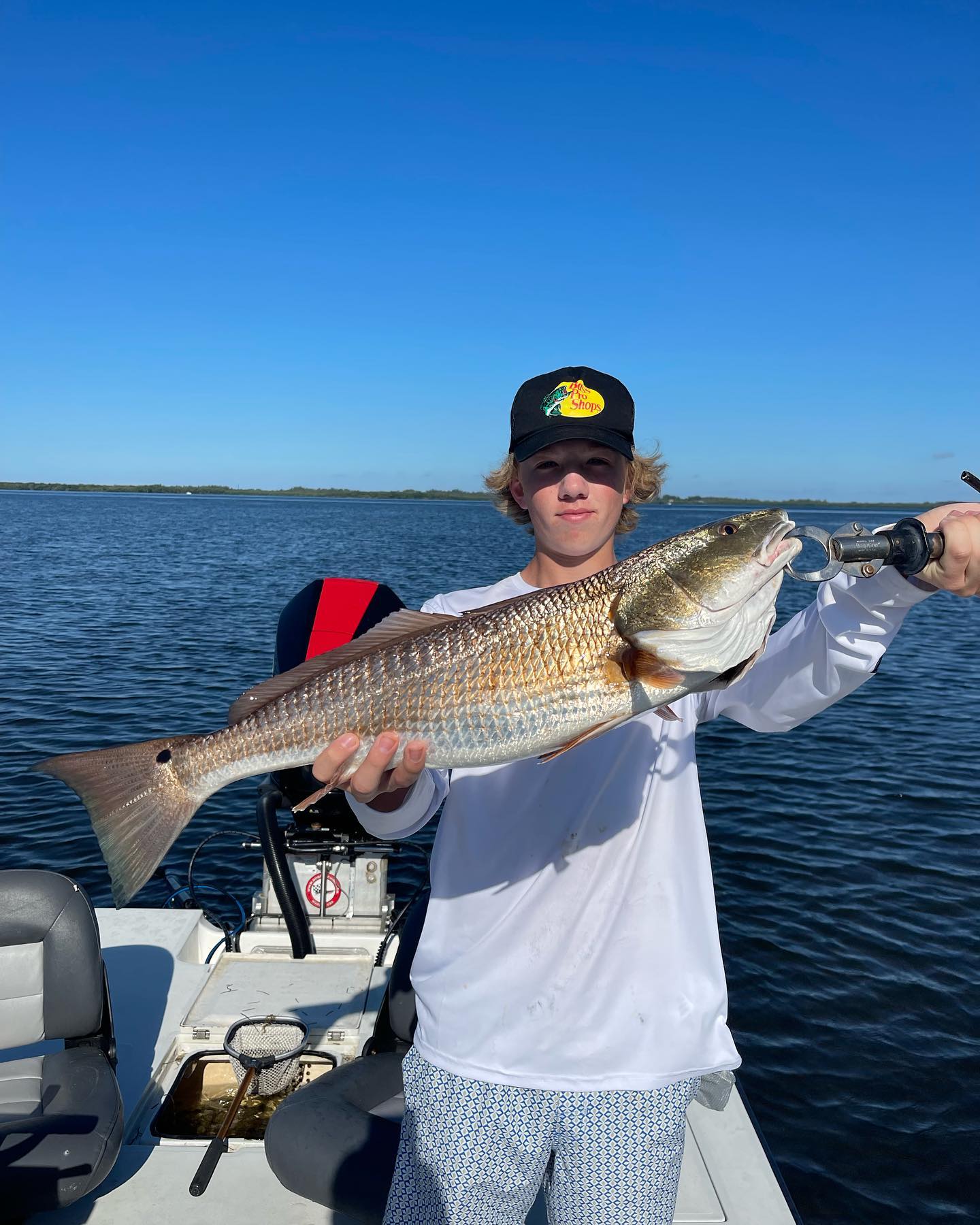A fisherman reeling in a large redfish in Fort Myers