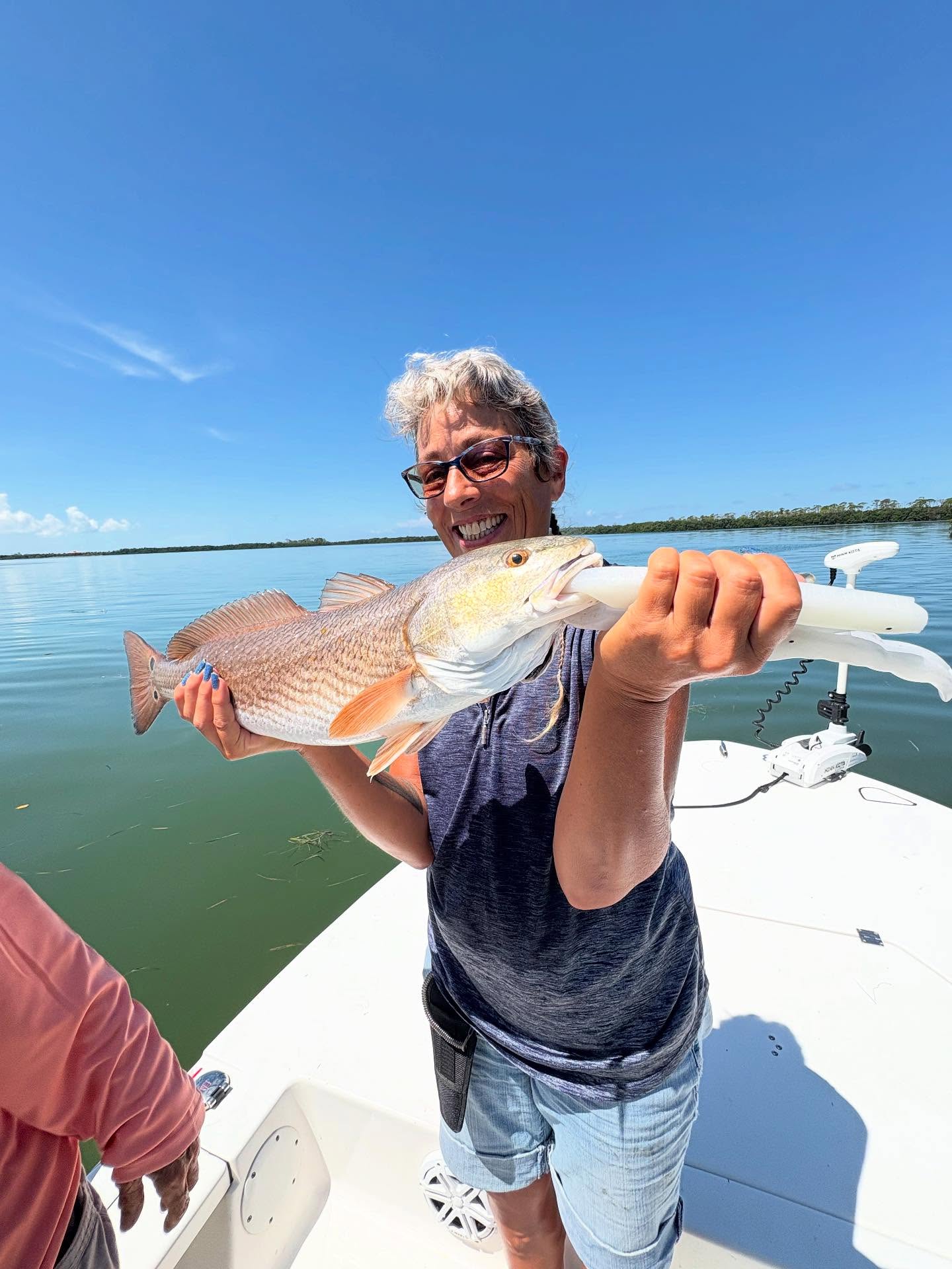 A person fishing for a redfish in FL