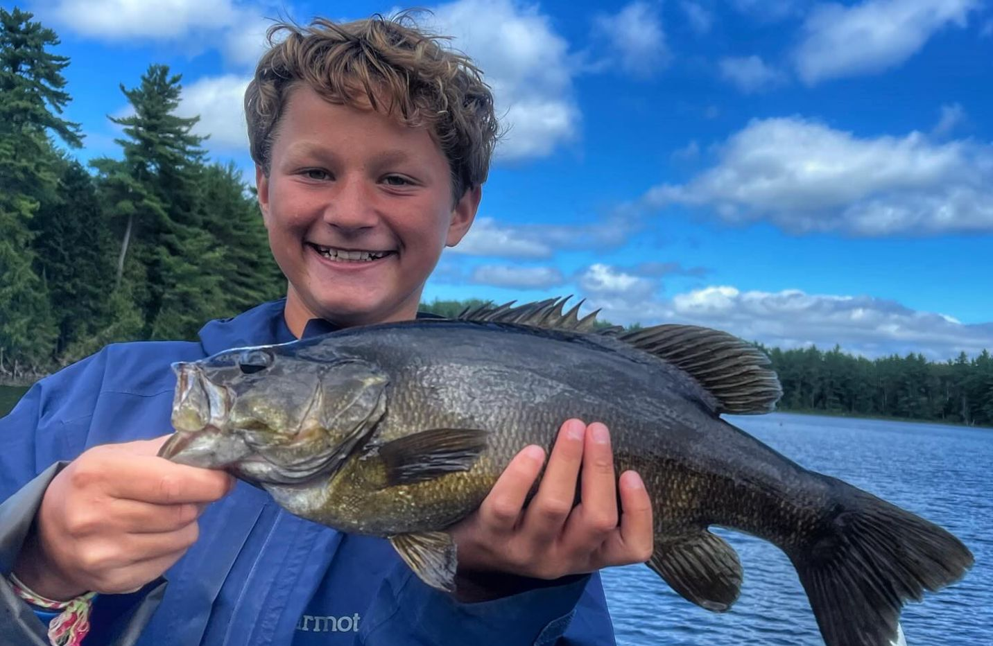 A lone angler fishing in Maine with a medium-sized catch