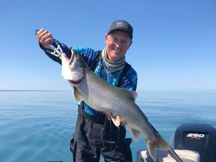 A person fishing in Erie, holding a 21-inch fish
