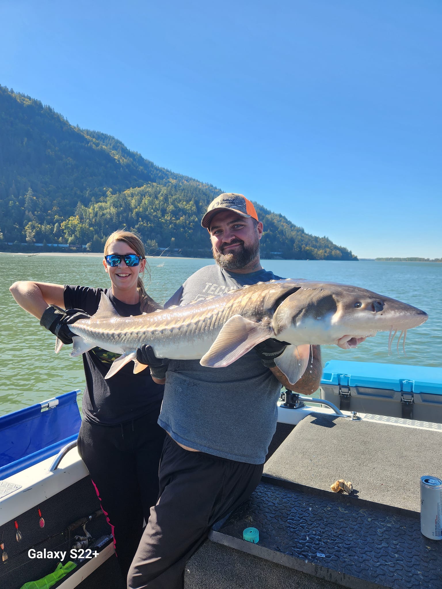 Fisherman holding a large white sturgeon in BC