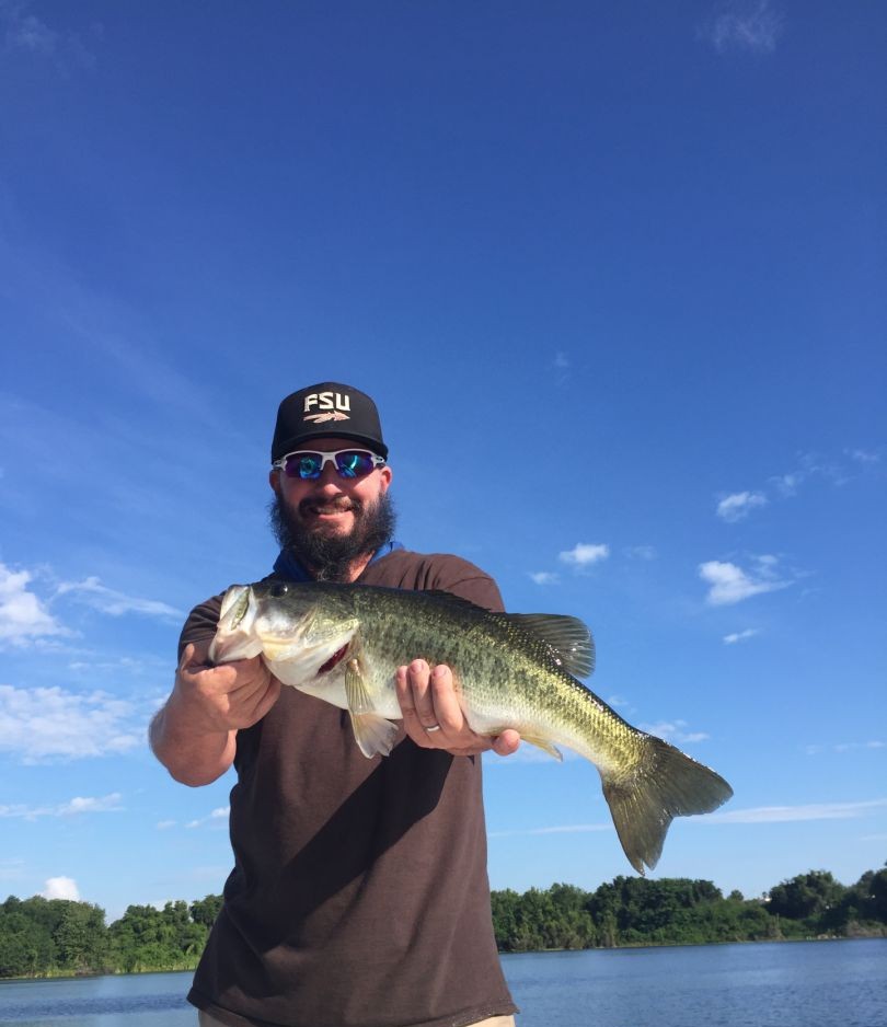 Angler holding large bass fish on lake in Winter Haven FL