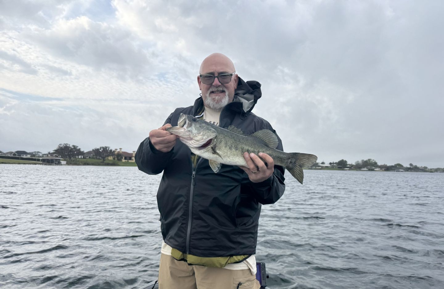 Angler holding caught bass on lake in Winter Haven FL