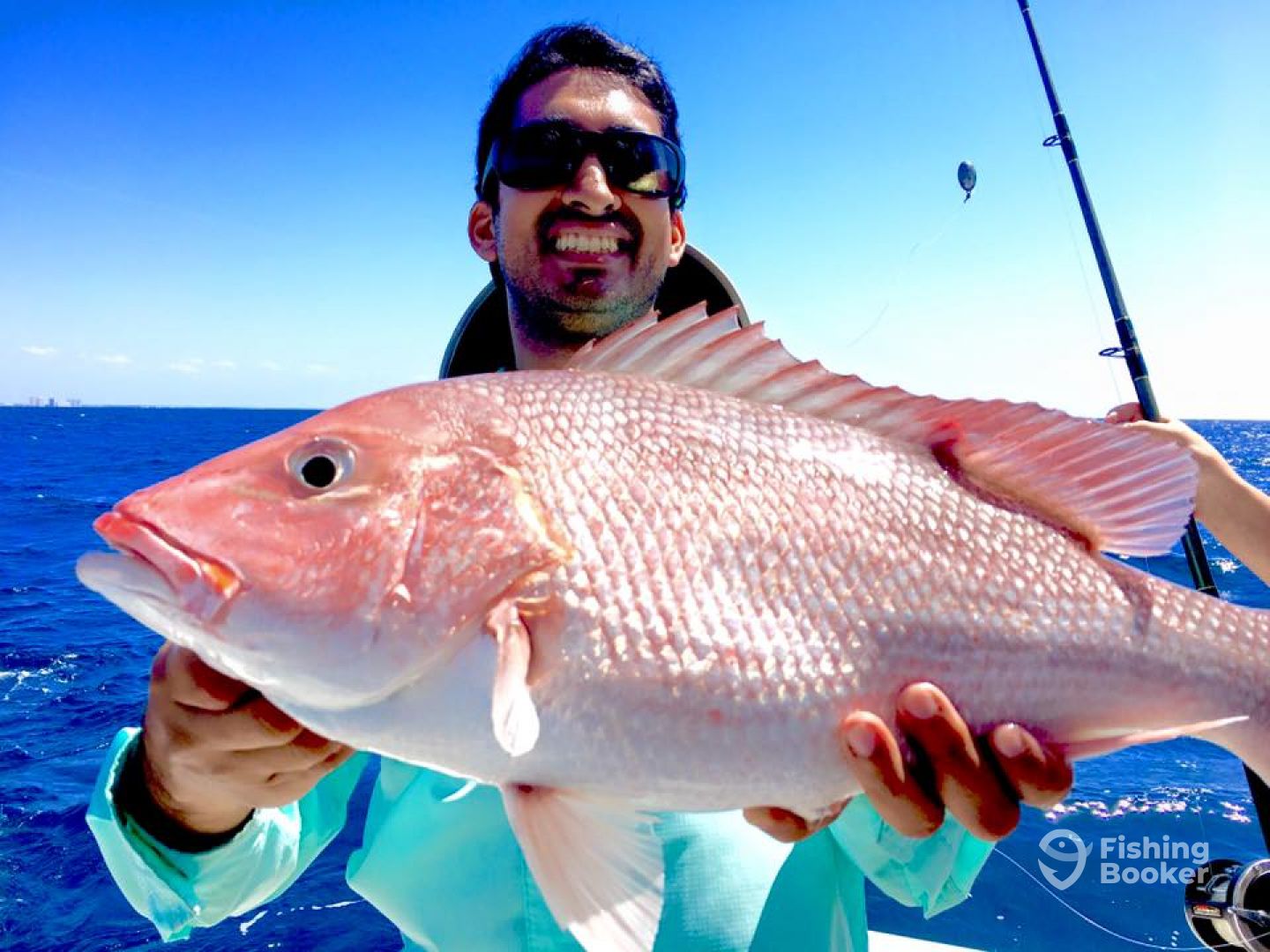 A fisherman holding a 27-inch fish in Destin