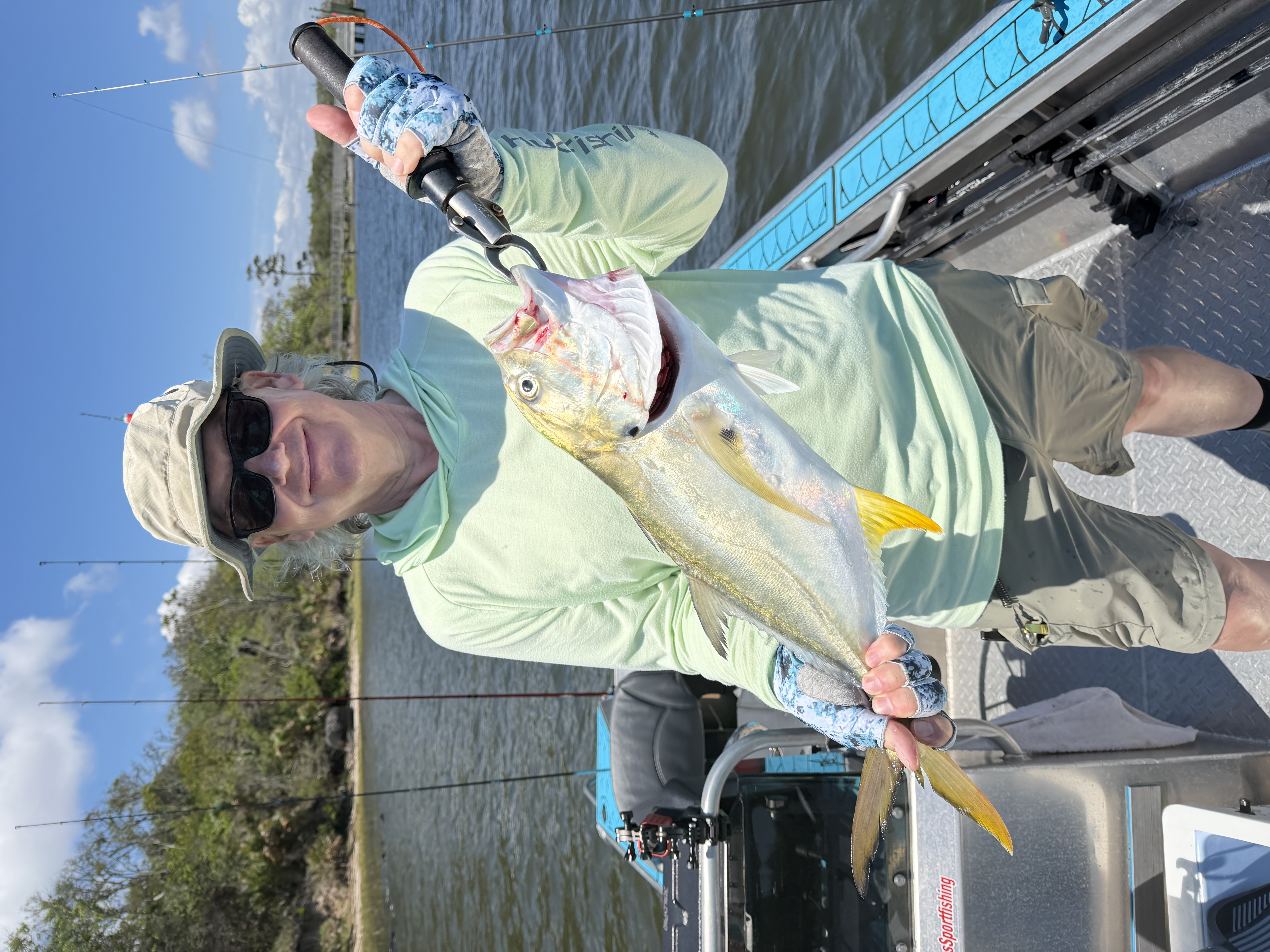 Angler holding caught Crevalle Jack fish on fishing charter boat in Jacksonville FL waters