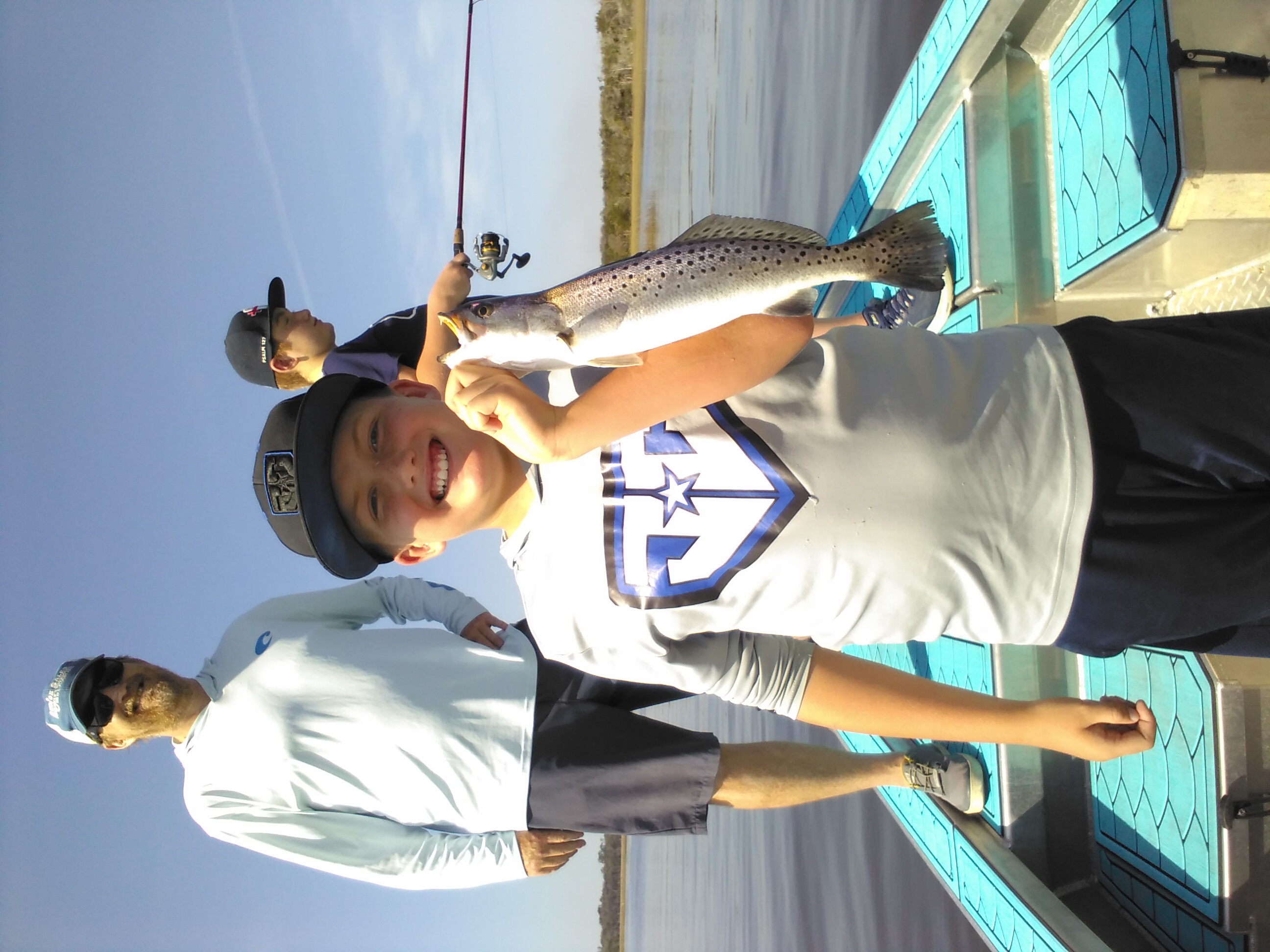 Speckled trout catch from Jacksonville FL fishing charter with fishing rod and boat dock visible