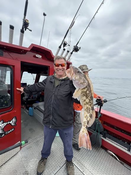 Angler holding large lingcod catch on fishing boat in Myrtle Creek OR
