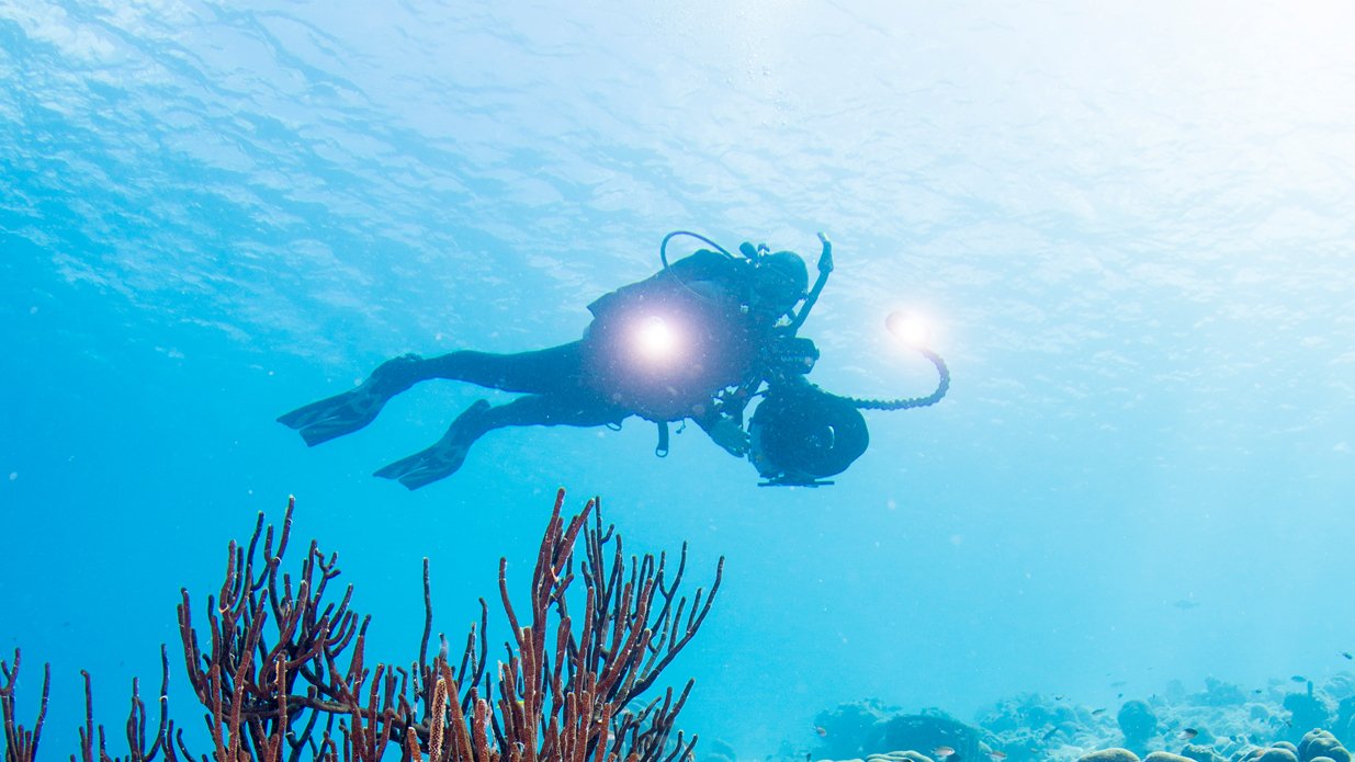 PADI Digital Underwater Photographer course student taking photos with camera and strobes underwater