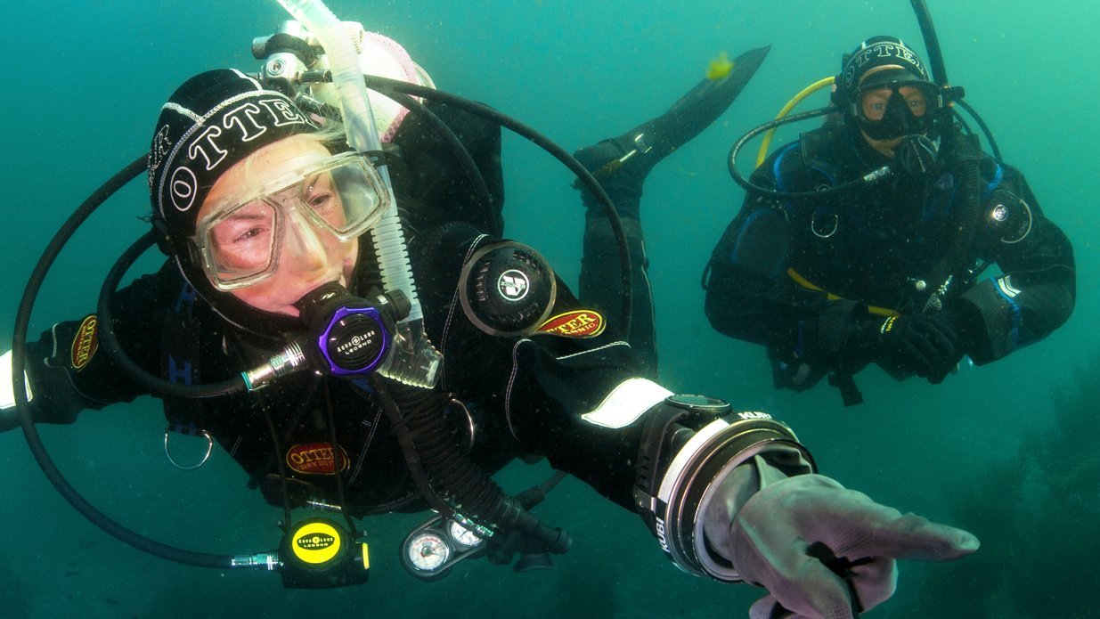 Scuba diver in drysuit underwater learning buoyancy control techniques during PADI certification