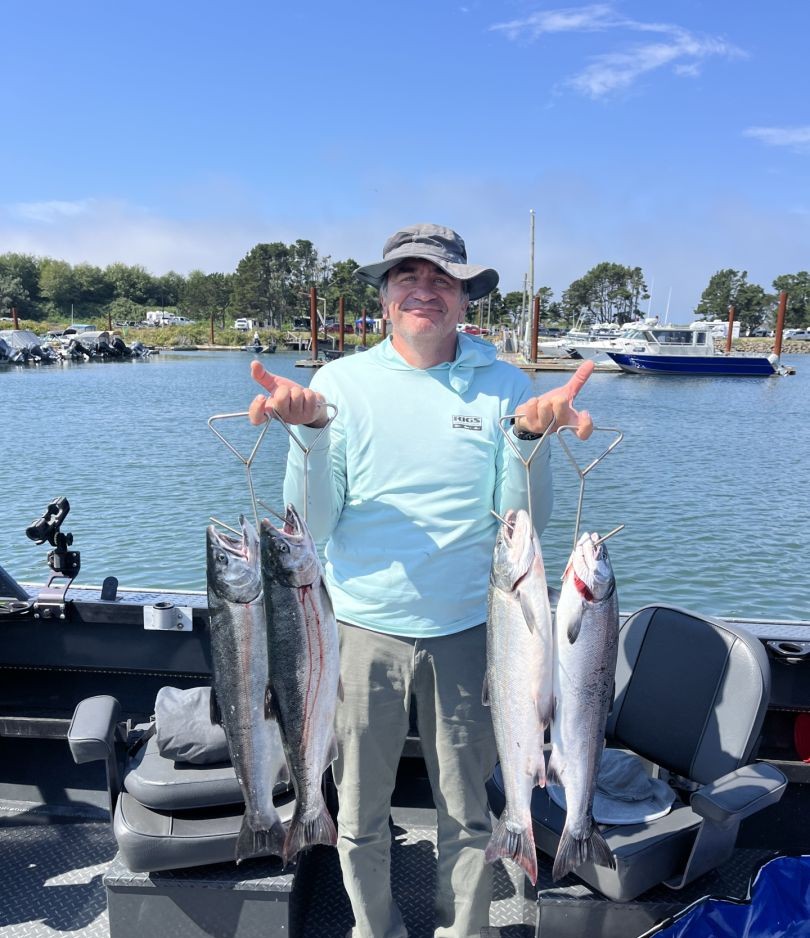 A person holding four fish while fishing in Portland