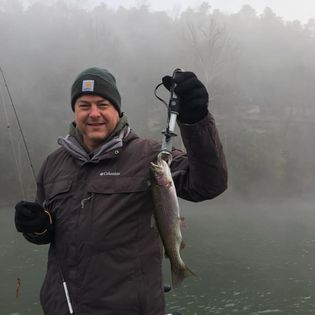 A fisherman holding a 13-inch fish in MO
