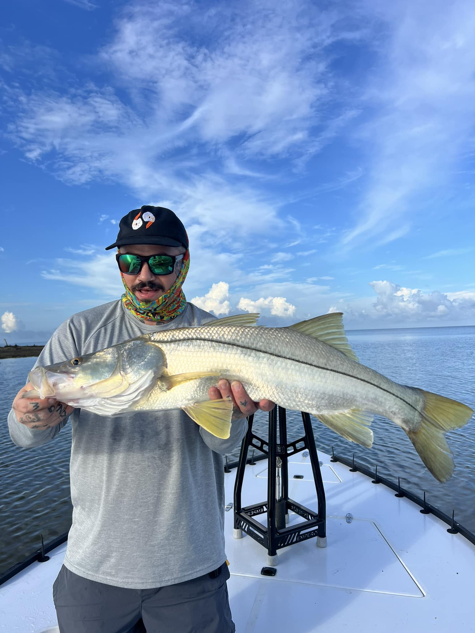 Angler holding large snook catch on fishing boat in Naples FL waters