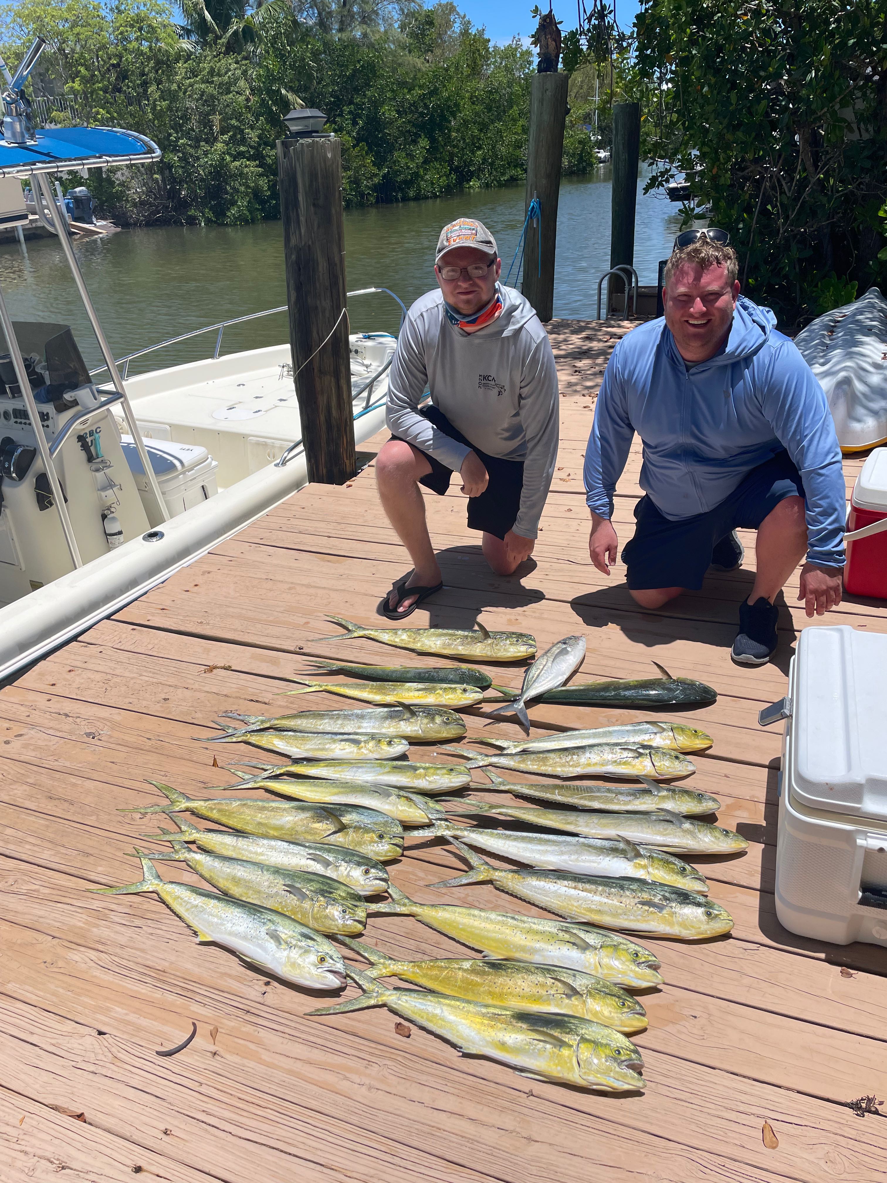 Fresh caught mahi mahi and blue runner fish displayed on wooden dock in Key Largo FL