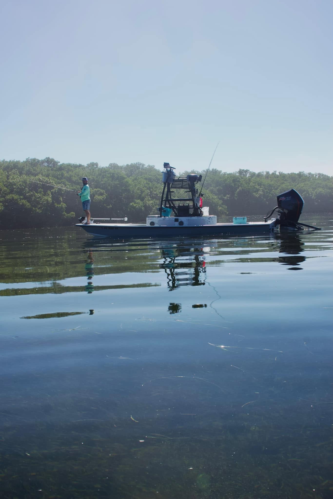 Fishing boat on calm water in Crystal River FL with mangrove shoreline