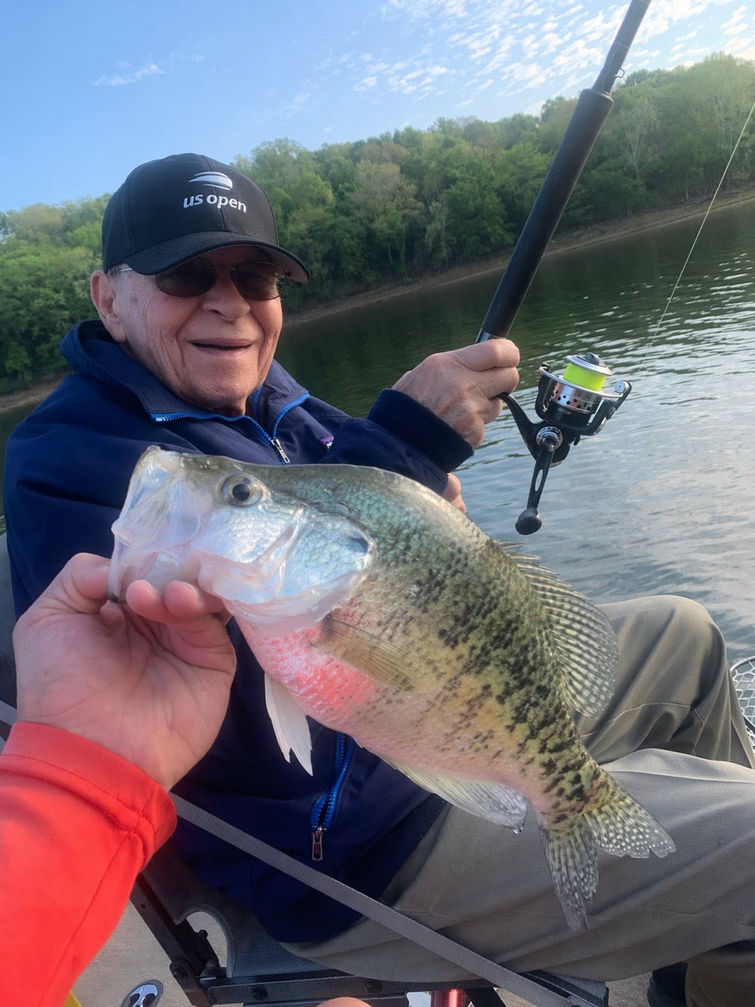 Angler holding freshly caught fish on boat in Rogers AR