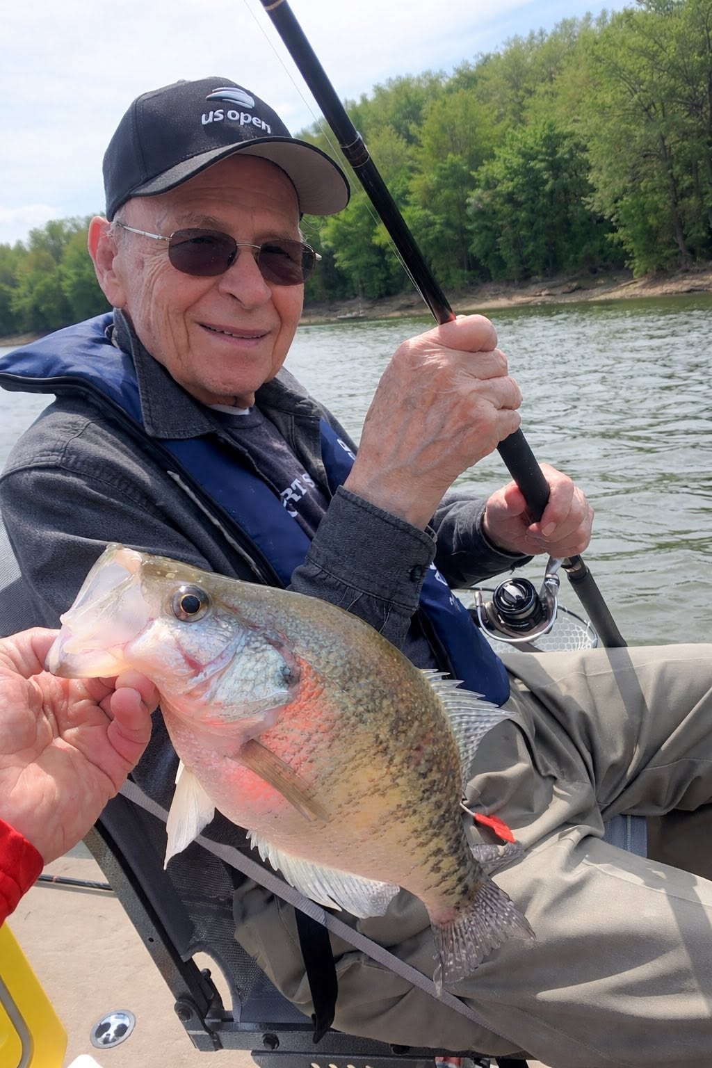 Angler holding freshly caught fish on boat in Rogers AR