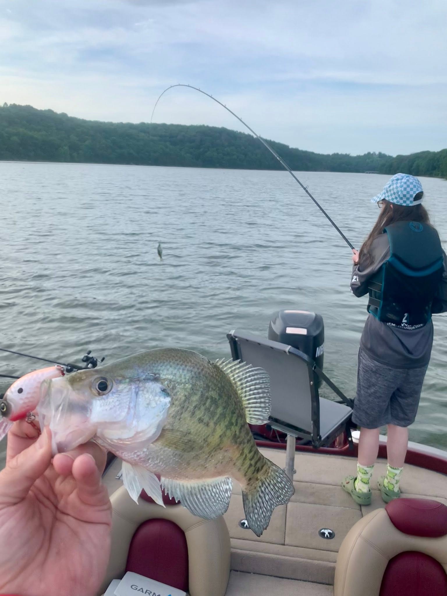 Fresh caught fish being held on fishing boat in Rogers Arkansas lake with angler in background