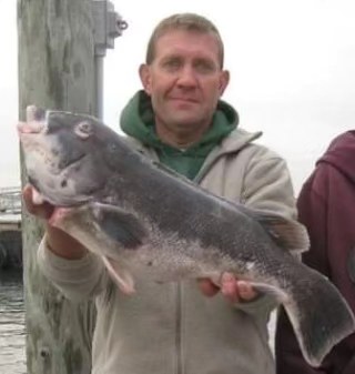 Angler holding a 20-inch fish caught while fishing in RI