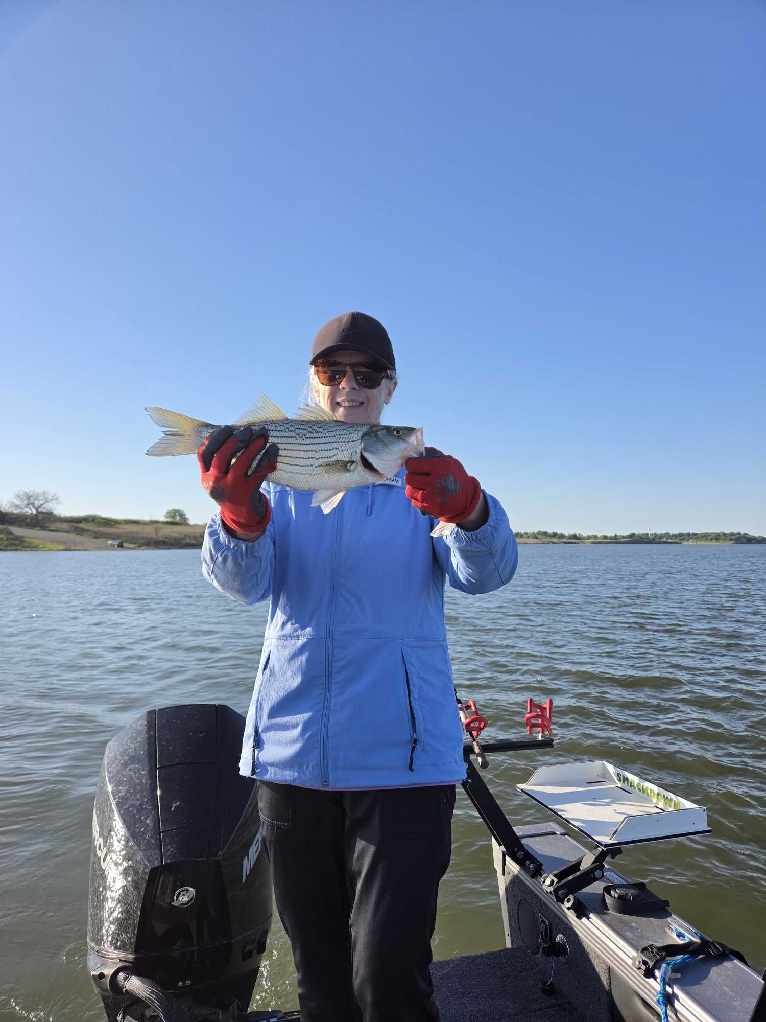 Angler holding freshly caught fish on boat in Manhattan Kansas waters