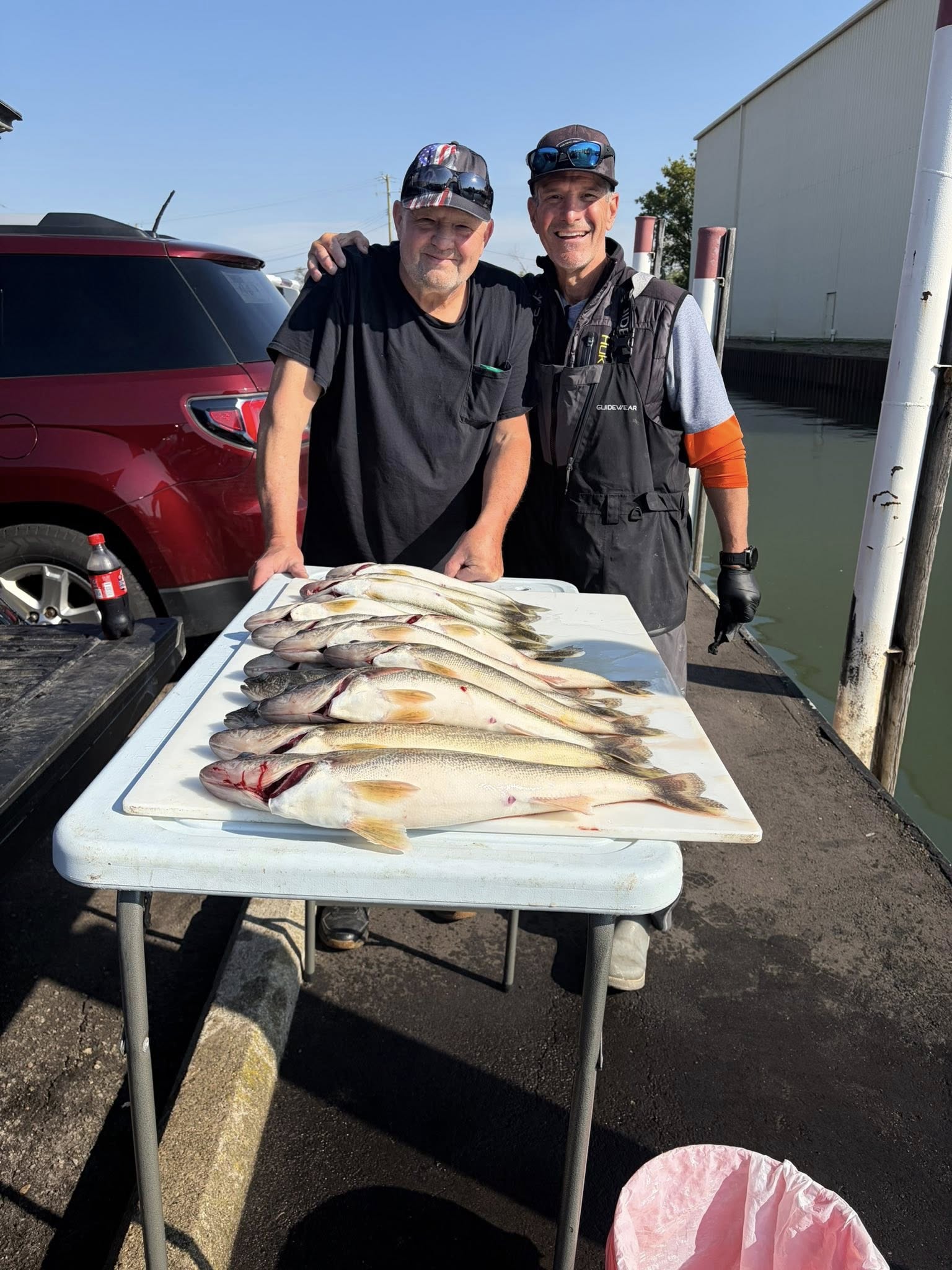 Two anglers displaying their walleye catch on a cleaning table in Detroit MI
