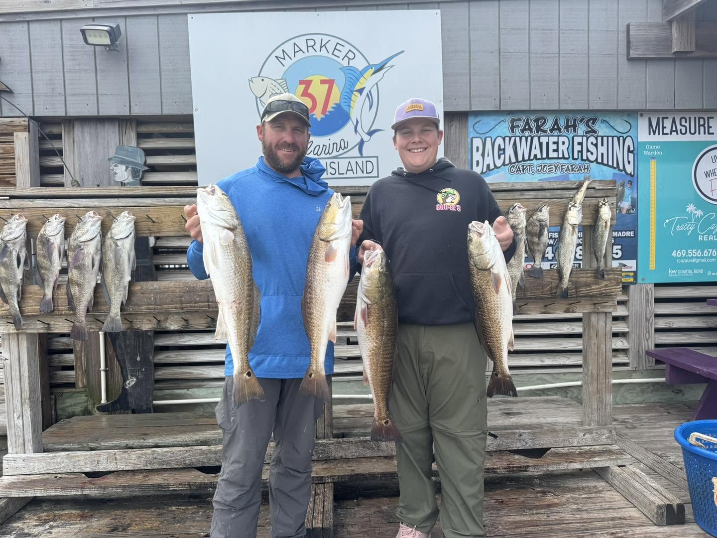 Successful fishing trip in Corpus Christi TX displaying caught redfish and black drum at marina dock