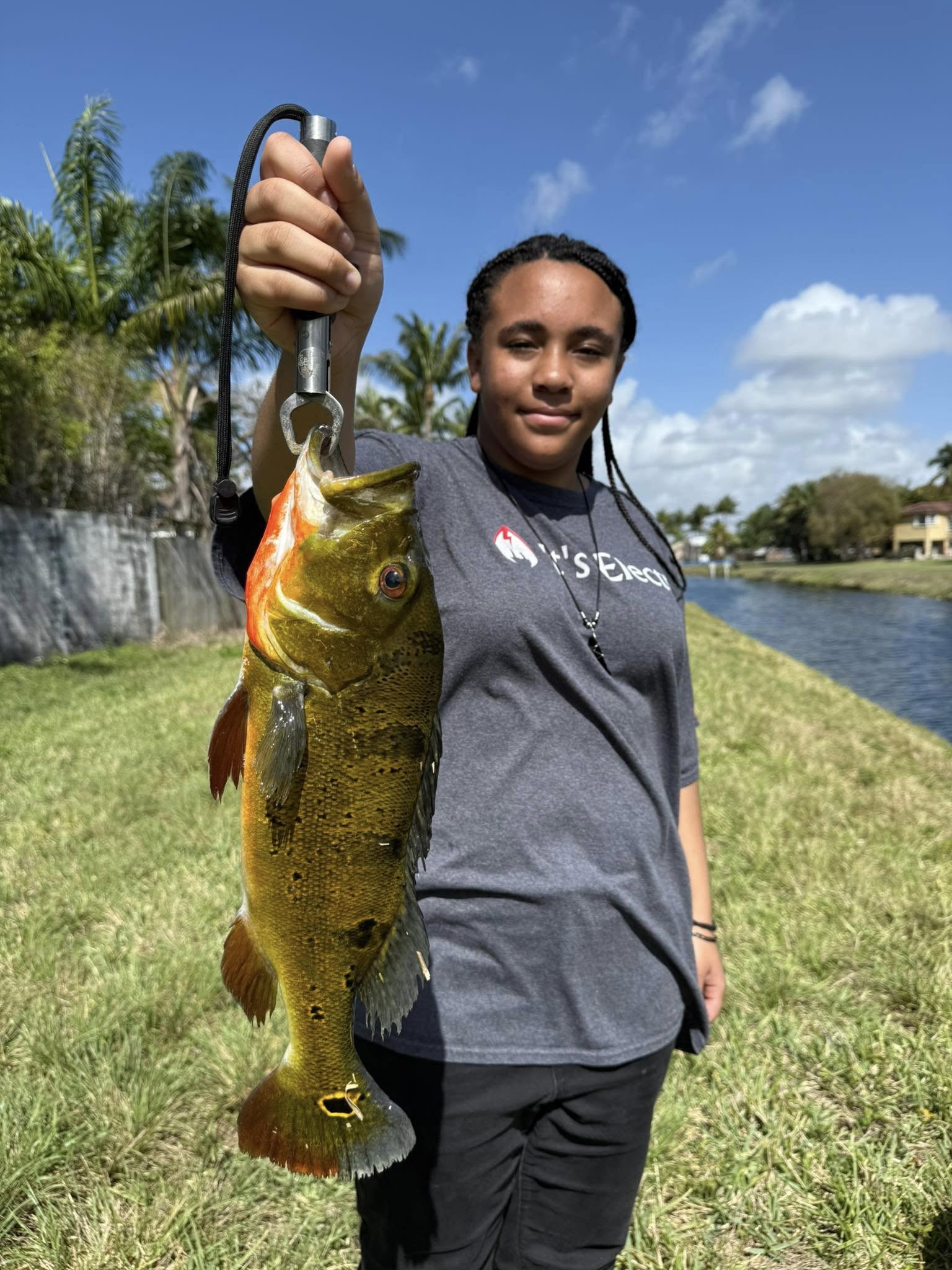 Freshly caught peacock bass held up after successful fishing trip in Miami FL