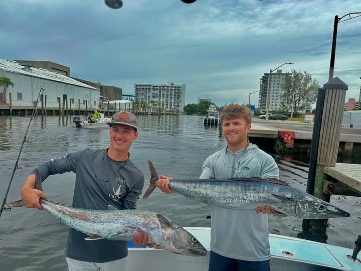 Two anglers displaying King Mackerel and Wahoo Fish catch at fishing dock in Pompano Beach FL