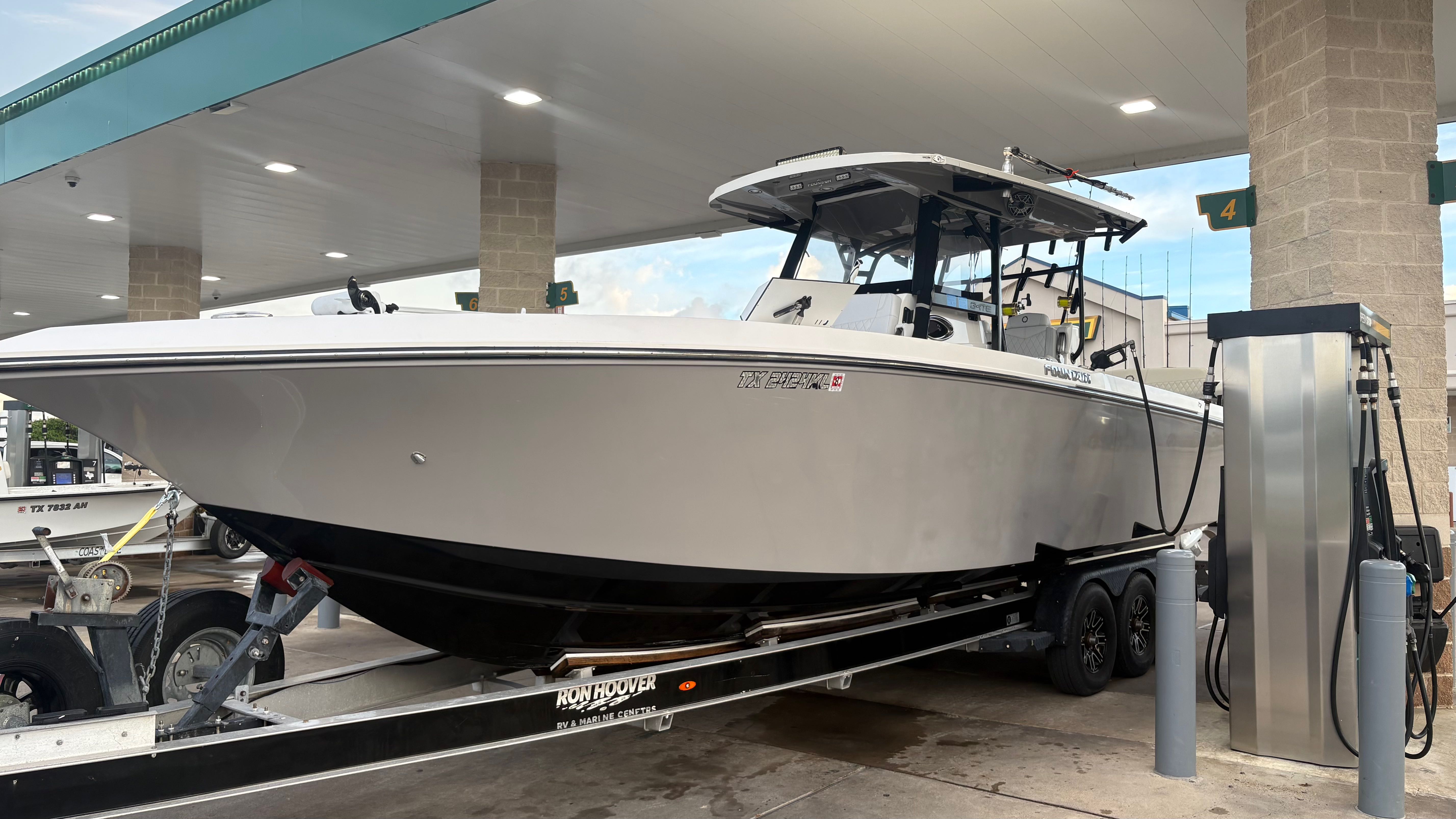 White center console fishing boat on trailer at fuel station in Port O'Connor TX