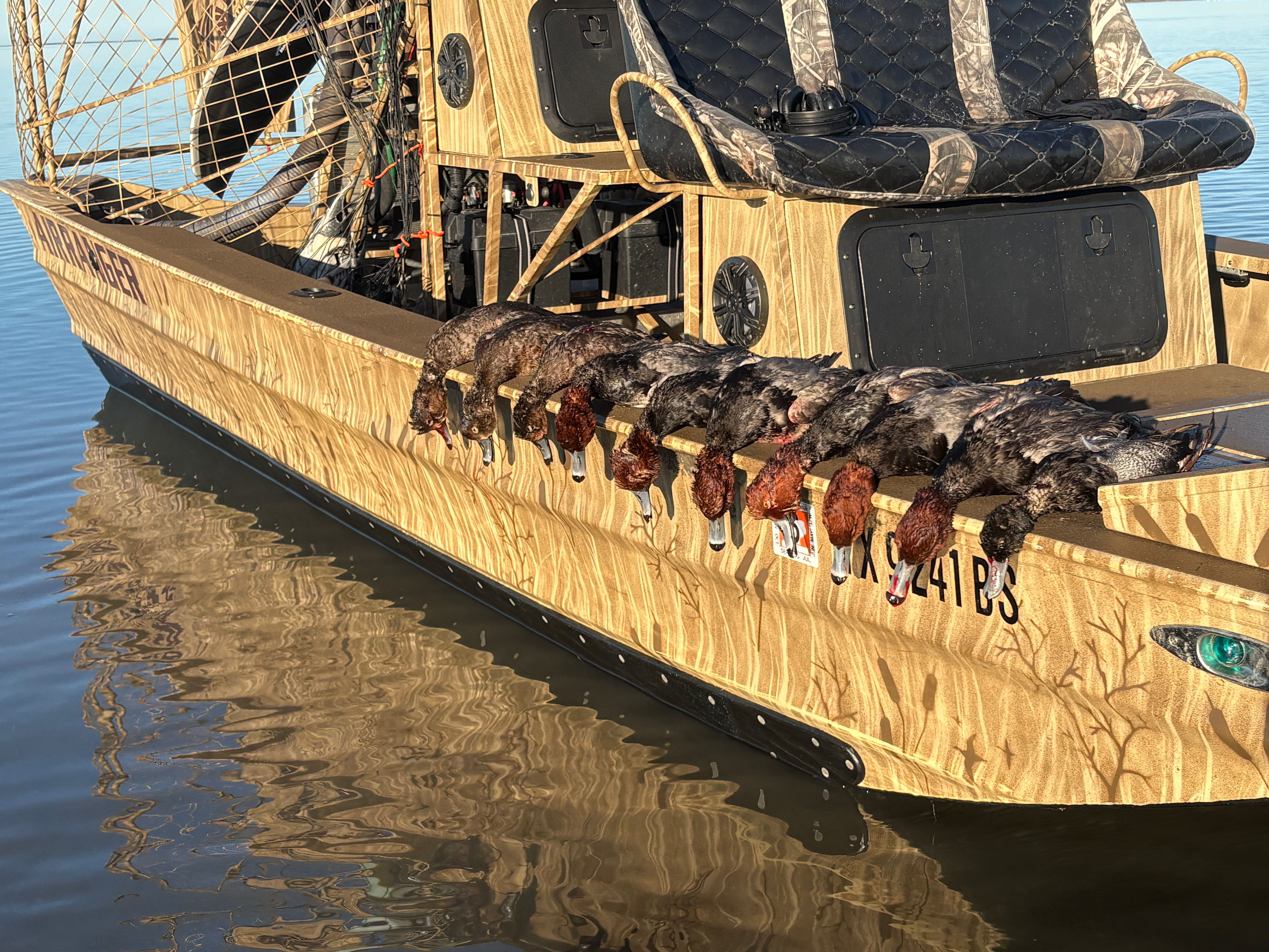 Hunting boat displaying harvested waterfowl lined up along the gunwale in Port O'Connor TX