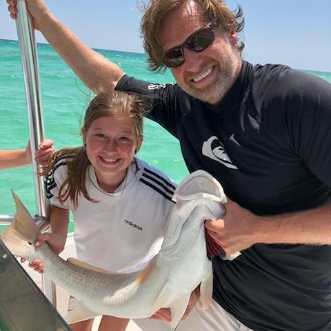 Two people fishing in Florida with a 19-inch fish