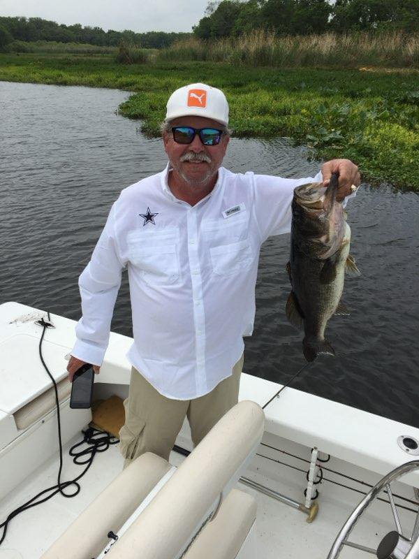 Angler holding freshly caught bass on boat in Alba TX fishing trip