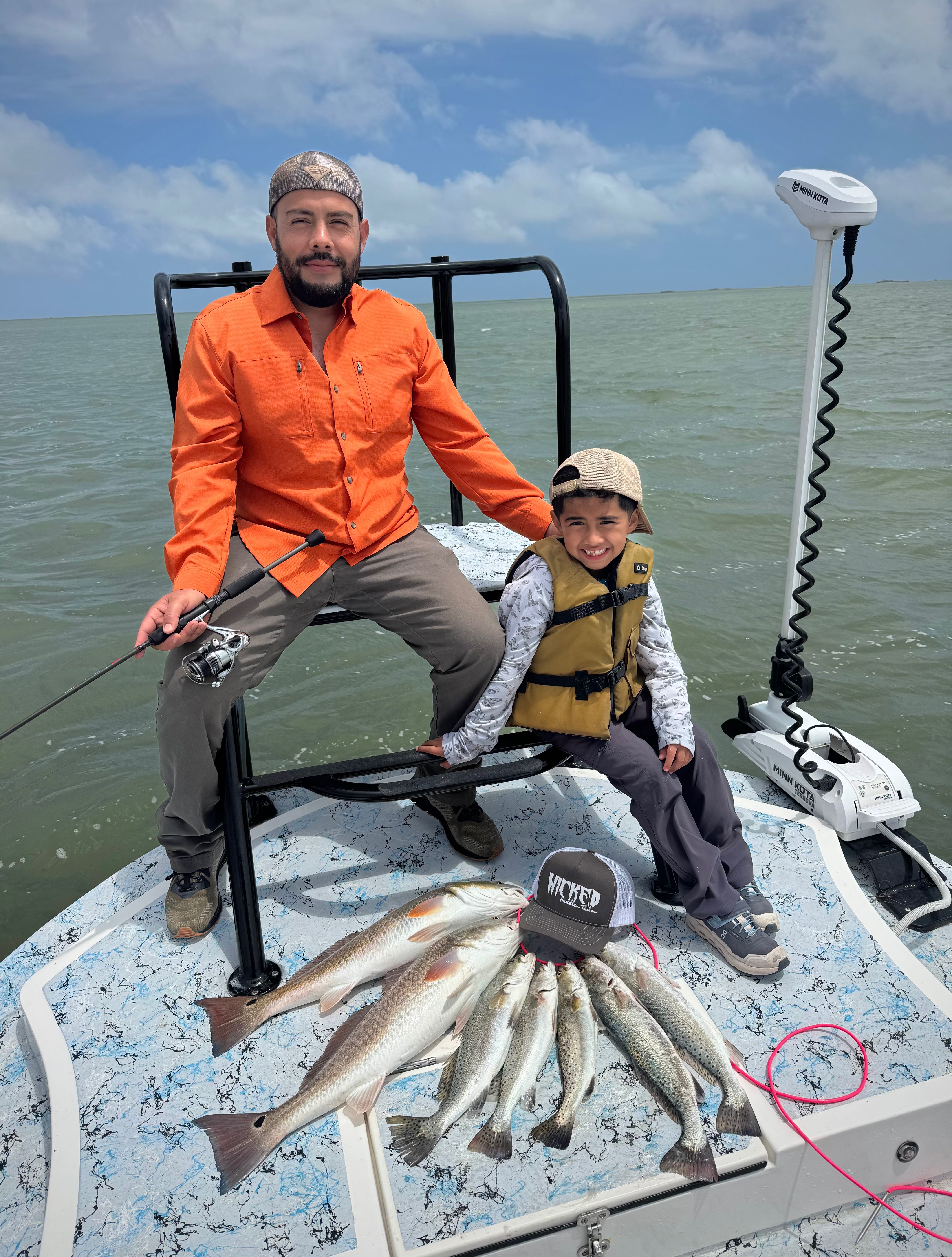 Successful fishing trip in Rio Hondo TX with redfish and speckled trout catch displayed on boat deck